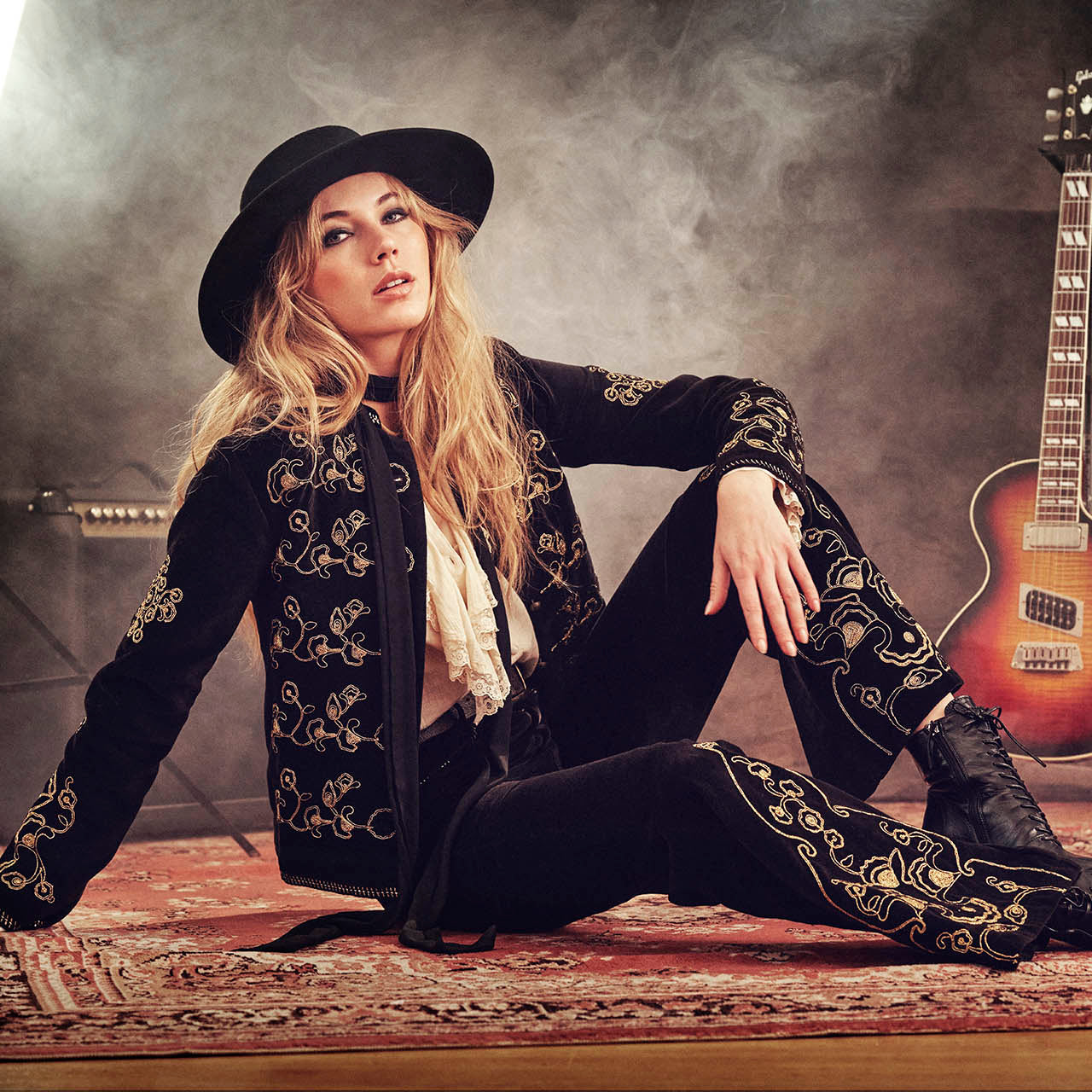 Hero banner for The Hippie Shake's heroes collection of vintage style clothing - Model leans against worktop in cream crochet midi dress.