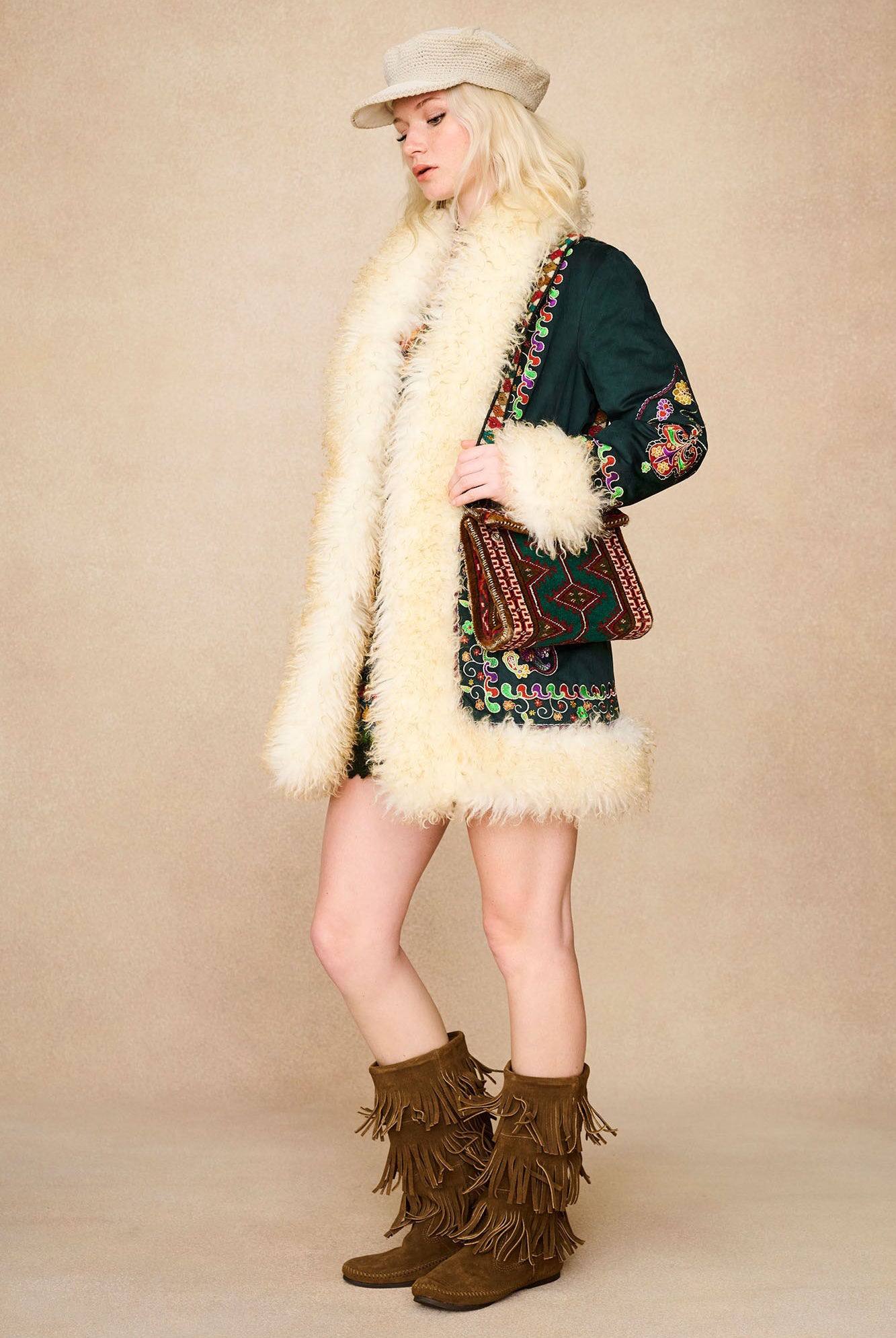 The Hippie Shake's green embroidered Penny Lane coat styled with a textured cream baker hat and fringe boots.
