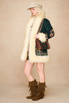 The Hippie Shake's green embroidered Penny Lane coat styled with a textured cream baker hat and fringe boots.