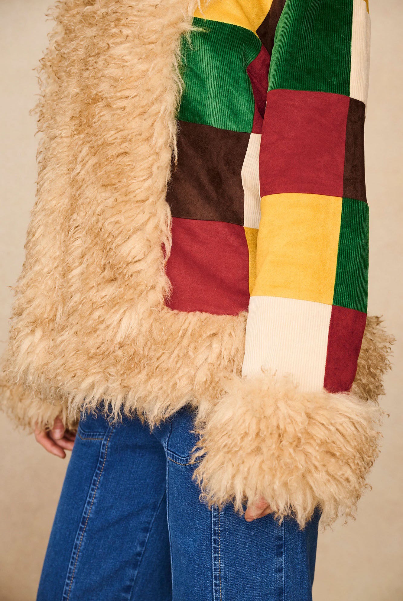 Close-up of The Hippie Shake's Penny Lane coat sleeve showing bold patchwork and faux fur cuff.