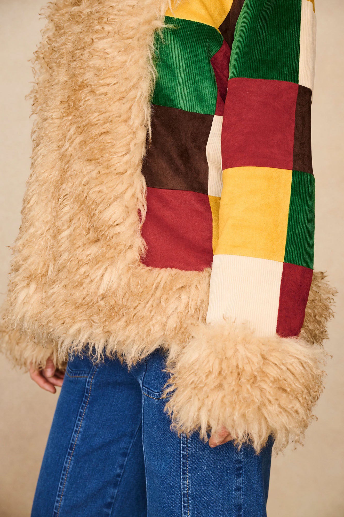 Close-up of The Hippie Shake's Penny Lane coat sleeve showing bold patchwork and faux fur cuff.