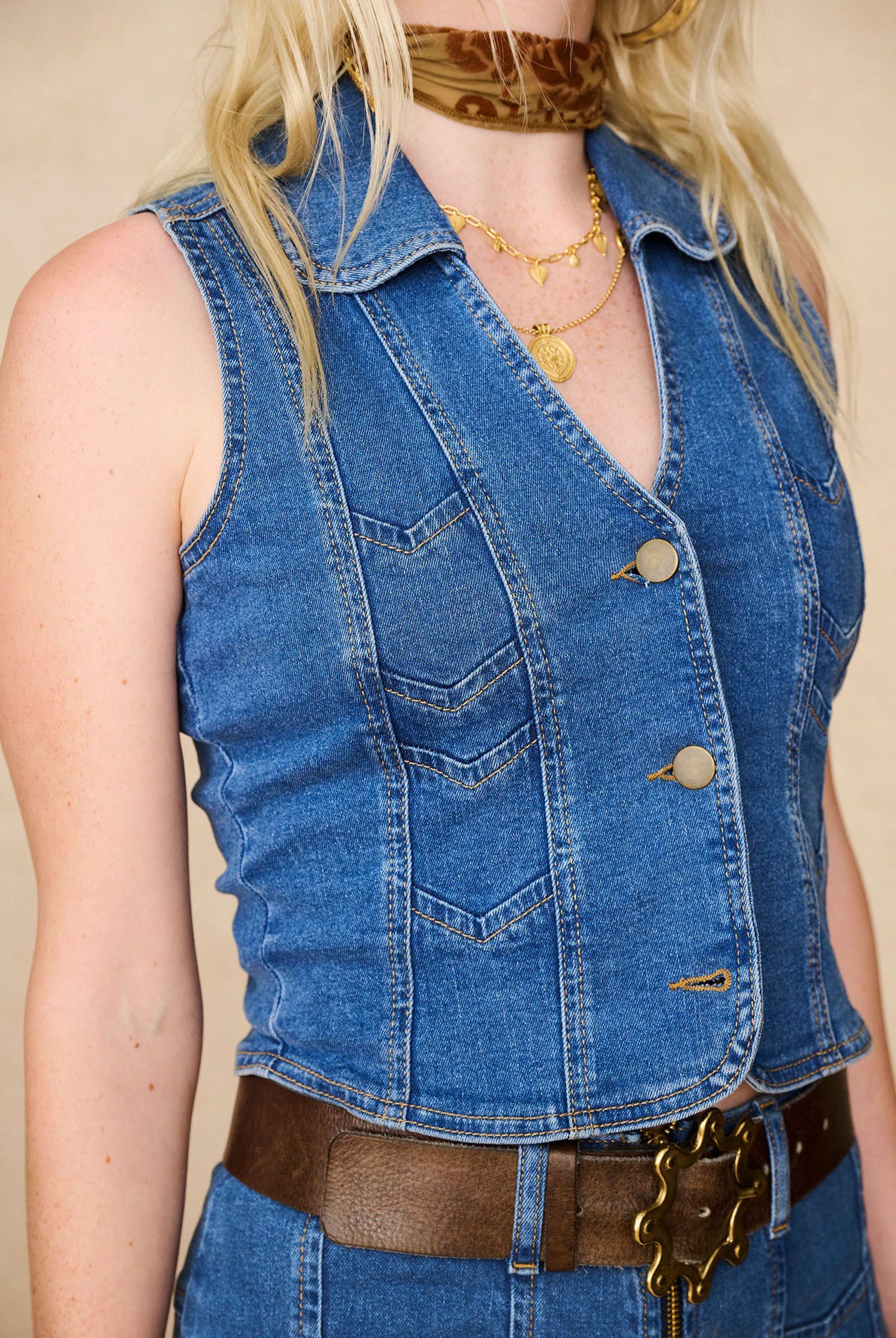 Close-up of The Hippie Shake's chevron denim waistcoat vest showing gold button detailing and vintage-inspired chevron stitching.