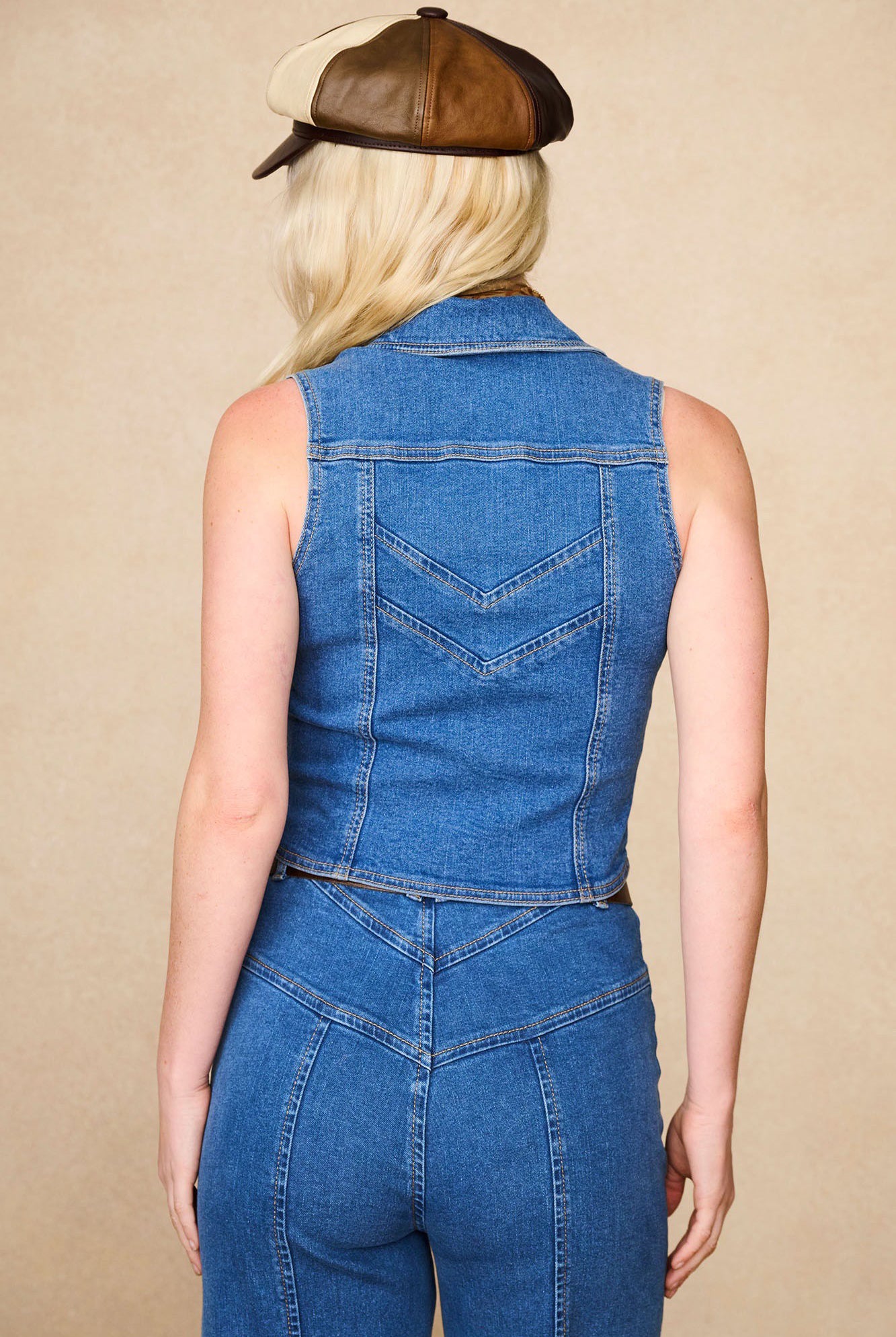 Back view of The Hippie Shake's chevron denim waistcoat vest and matching denim flares, styled with our brown baker hat.