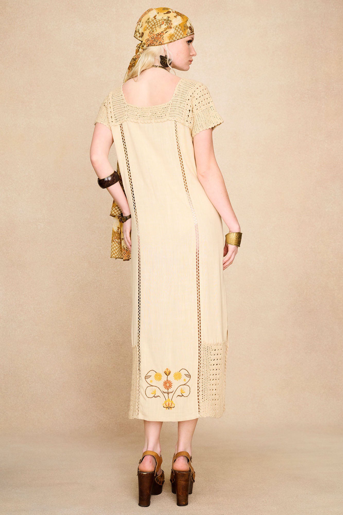 Back view of The Hippie Shake's cream crochet embroidered midi dress highlighting the 70s inspired shape and intricate floral detailing.