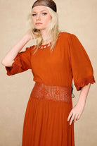 Close-up of the crochet embroidered waistband and sleeves on The Hippie Shake's orange crochet midi dress.