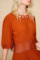 Detail shot of the neckline and waistband on The Hippie Shake's vintage inspired orange crochet midi dress.