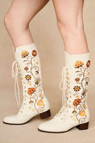 The Hippie Shake's cream Penny Lane embroidered floral boots with lace-up front and orange floral stitching.