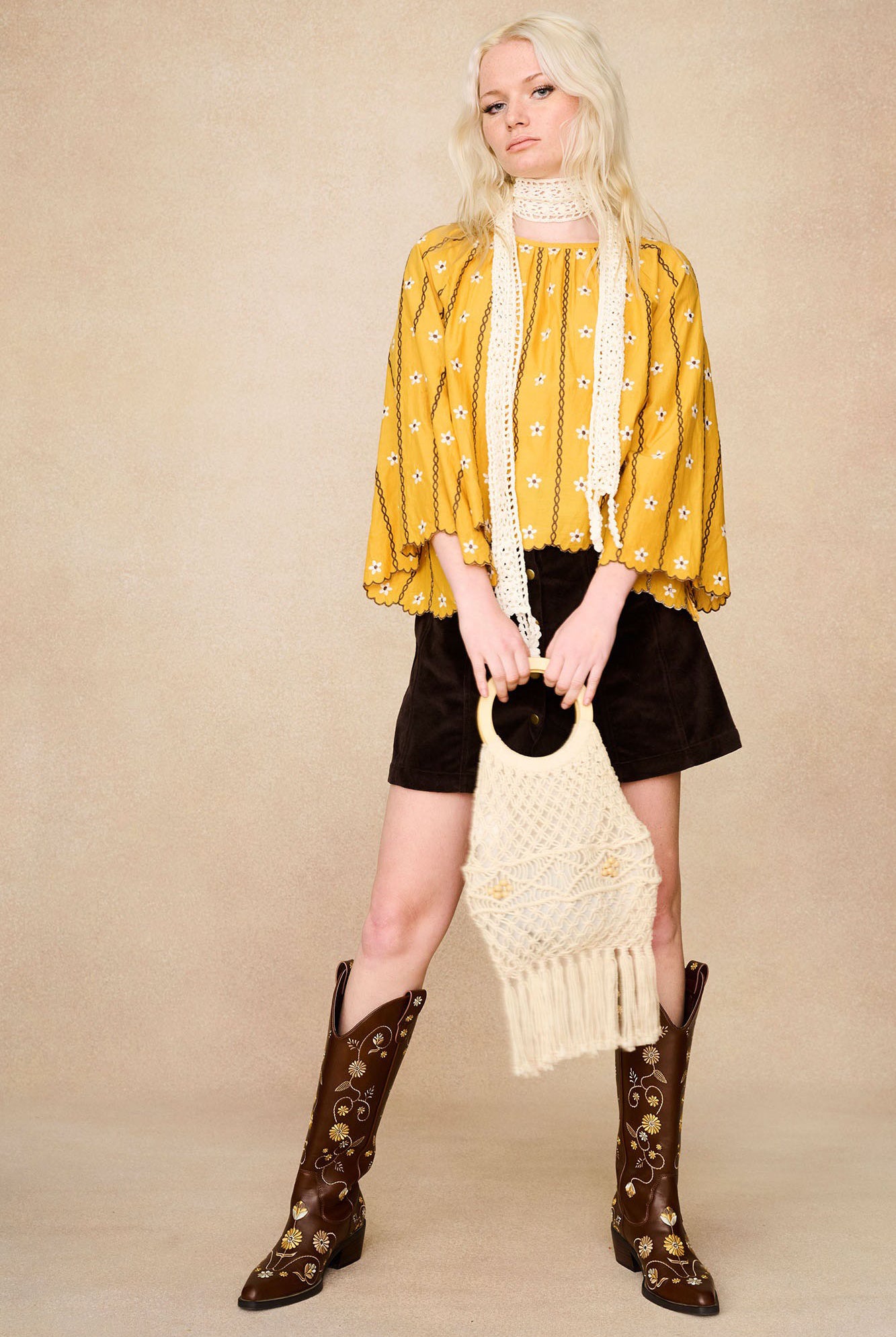 Full-length shot featuring The Hippie Shake's yellow embroidered smock top, styled with brown velvet skirt and Penny Lane boots.