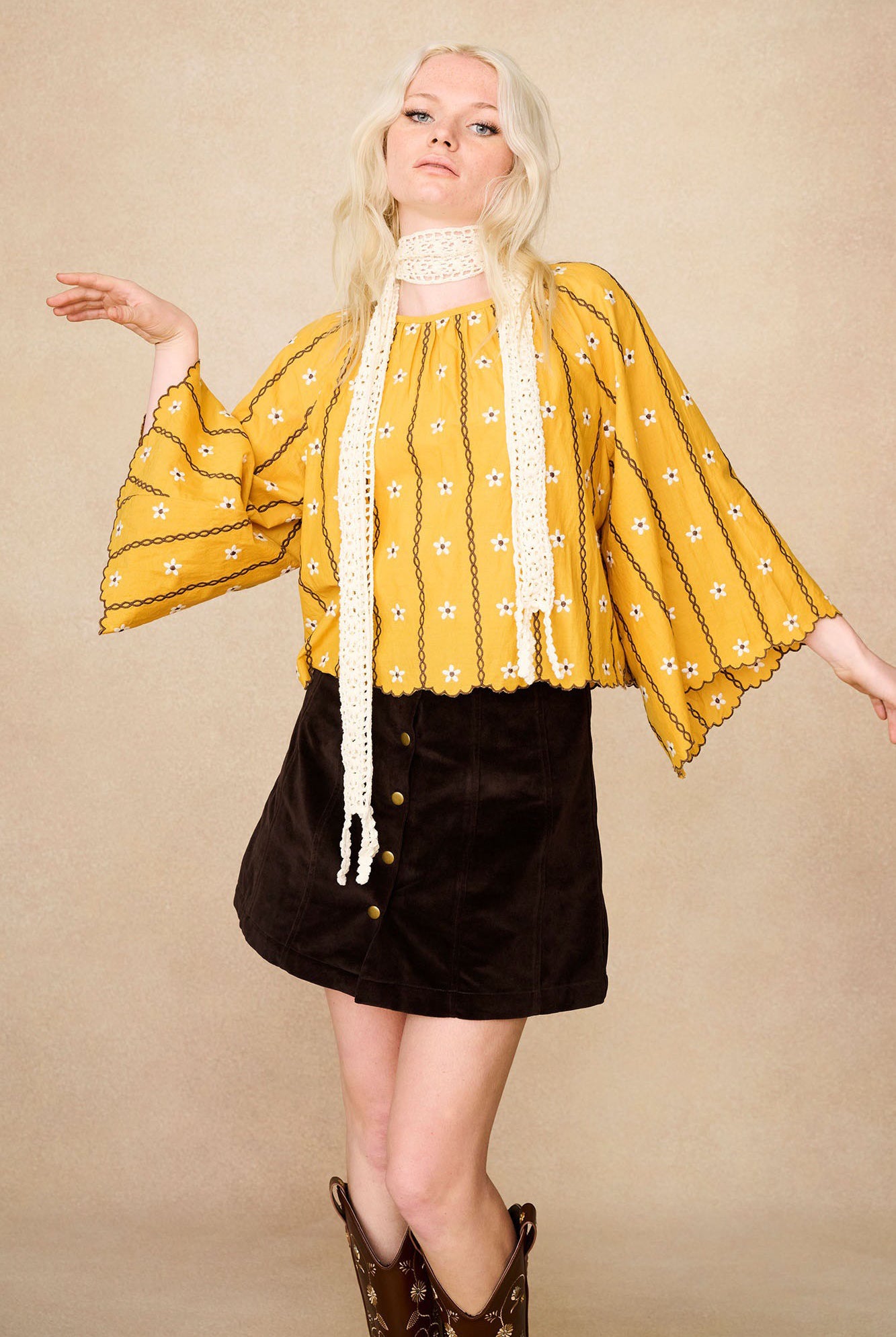 Model wearing The Hippie Shake's brown velvet mini skirt with yellow floral blouse.