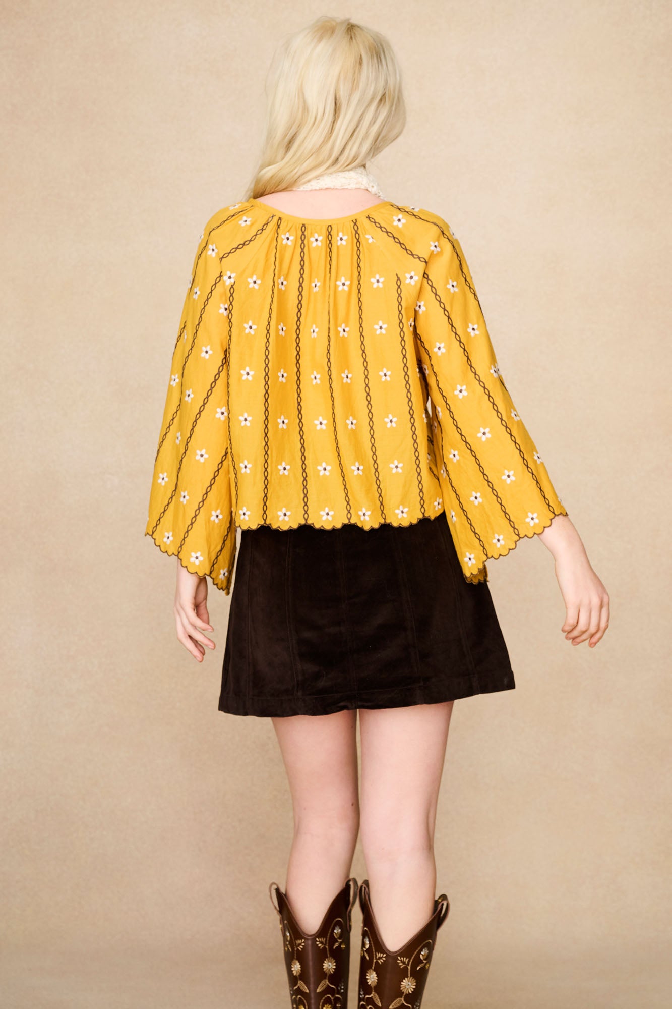 Back view of The Hippie Shake's yellow embroidered smock top showcasing the daisy embroidery and scalloped edges.