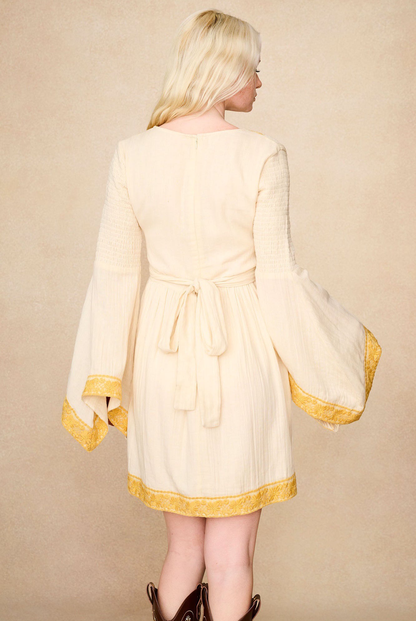 Back view of The Hippie Shake's cream lace trim mini dress showing its soft fabric and shirred waist.