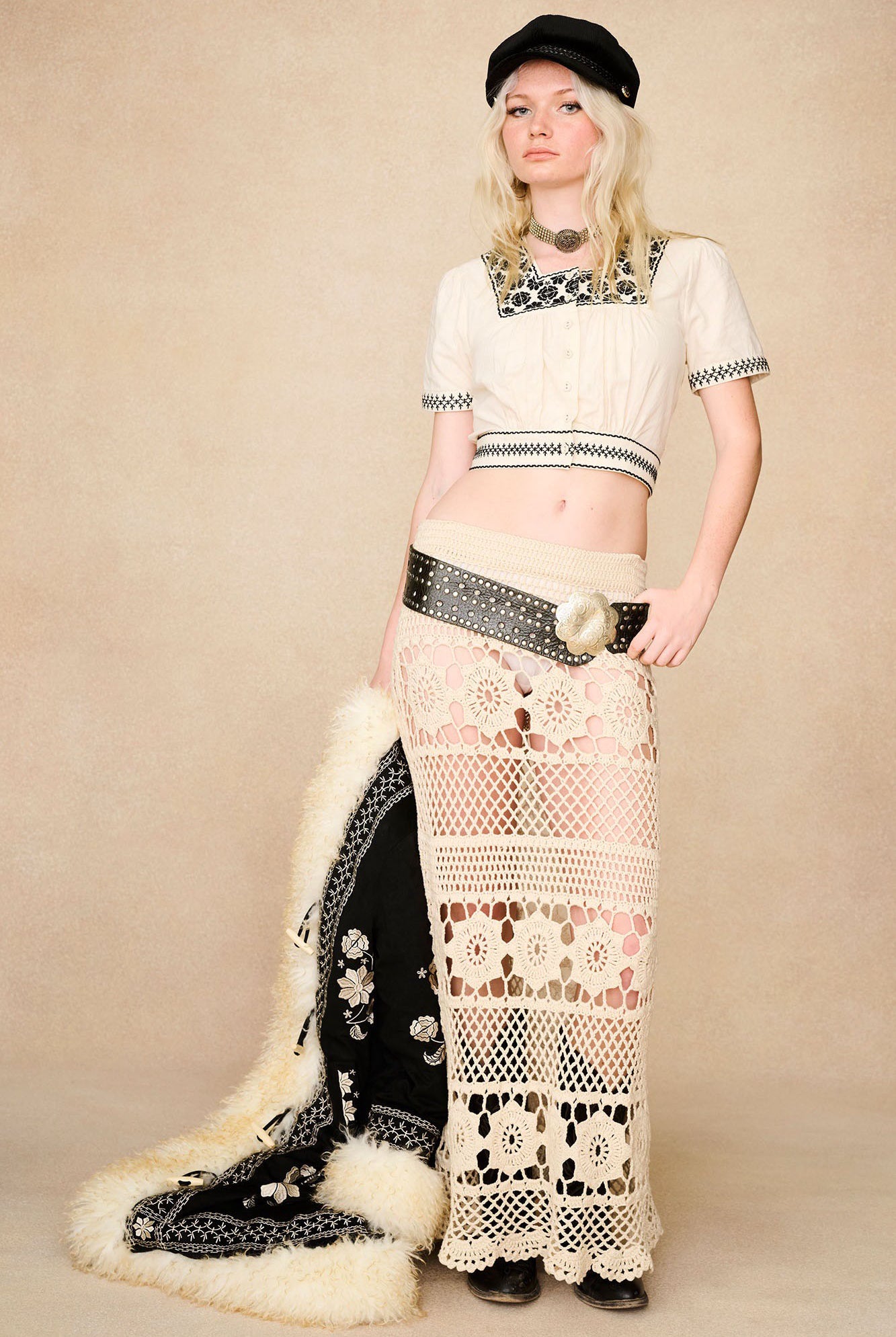 Styled with black cropped blouse, The Hippie Shake's cream crochet maxi skirt paired with black Penny Lane coat.