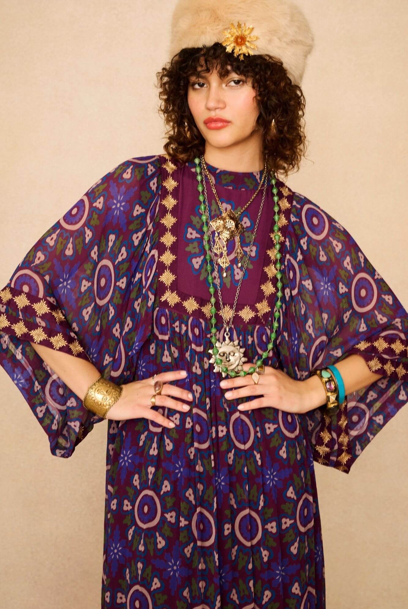 Model wears a 70s style bohemian maxi dress in a printed purple fabric with hand embroidery - close up
