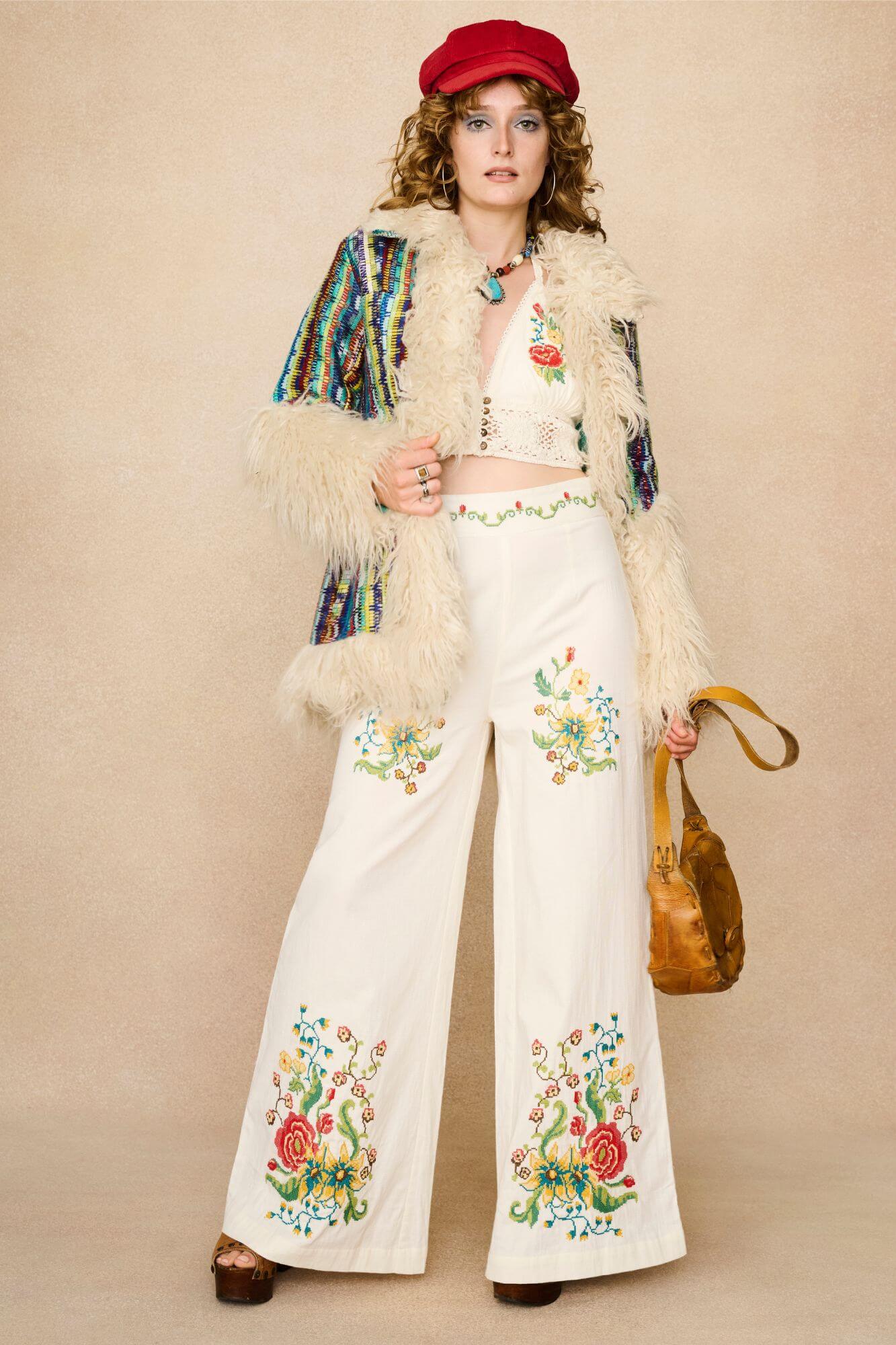 Woman wearing a red cap, floral embroidered top, and colourful necklace against a beige background - outfit combination