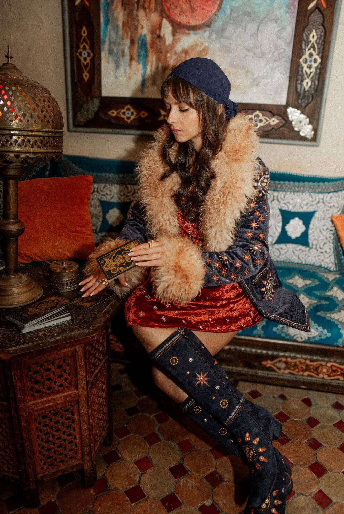 Model wears blue The Hippie Shake Penny Lane Coat and red velvet dress from House of the Rising Sun collection