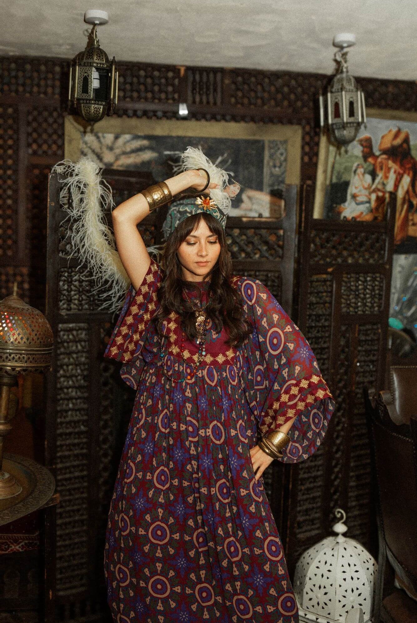 Model dancing wearing a 70s style bohemian maxi dress in a printed purple fabric with hand embroidery