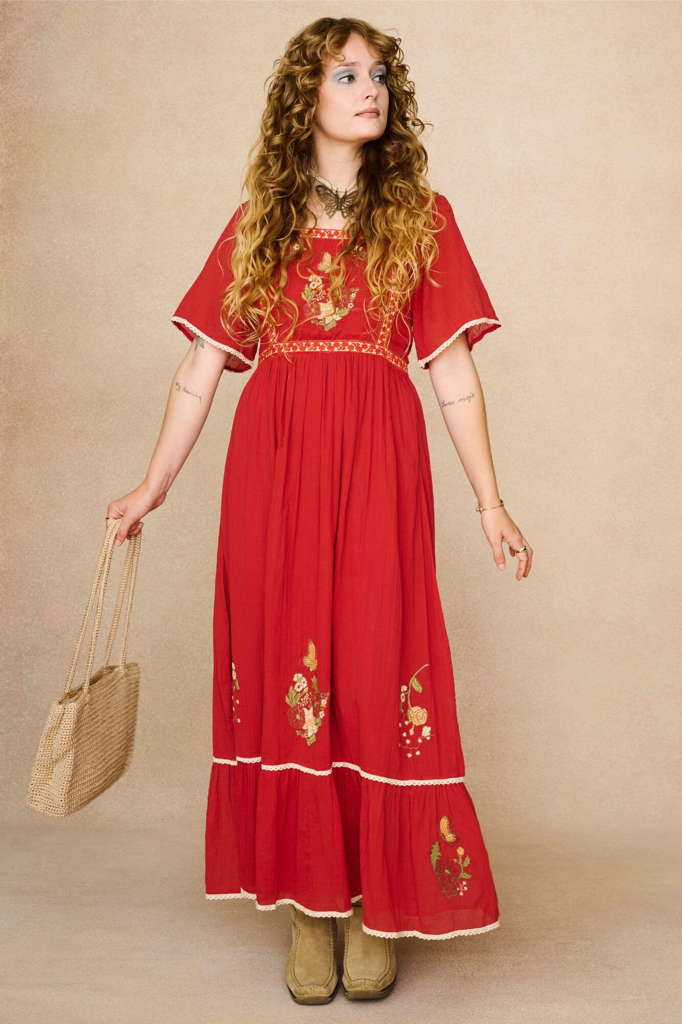Model wearing a red floaty maxi dress with embroidered details - front view