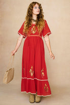 Model wearing a red floaty maxi dress with embroidered details - front view