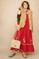 Model wearing a red floaty maxi dress with embroidered details - outfitted with jacket