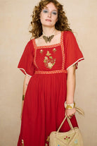 Model wearing a red floaty maxi dress with embroidered details - medium view