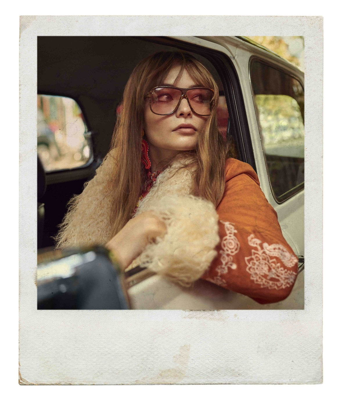 A polaroid photo of a model wearing the Penny Lane Coat by The Hippie Shake