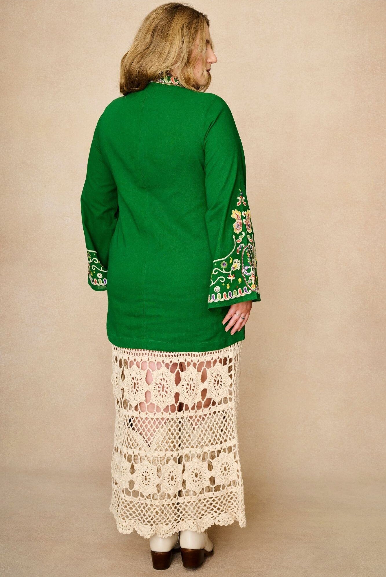 Back view of The Hippie Shake green folk embroidered mini dress in soft cotton with wide sleeves. A 70s-inspired boho mini dress made for festival and vintage styling.