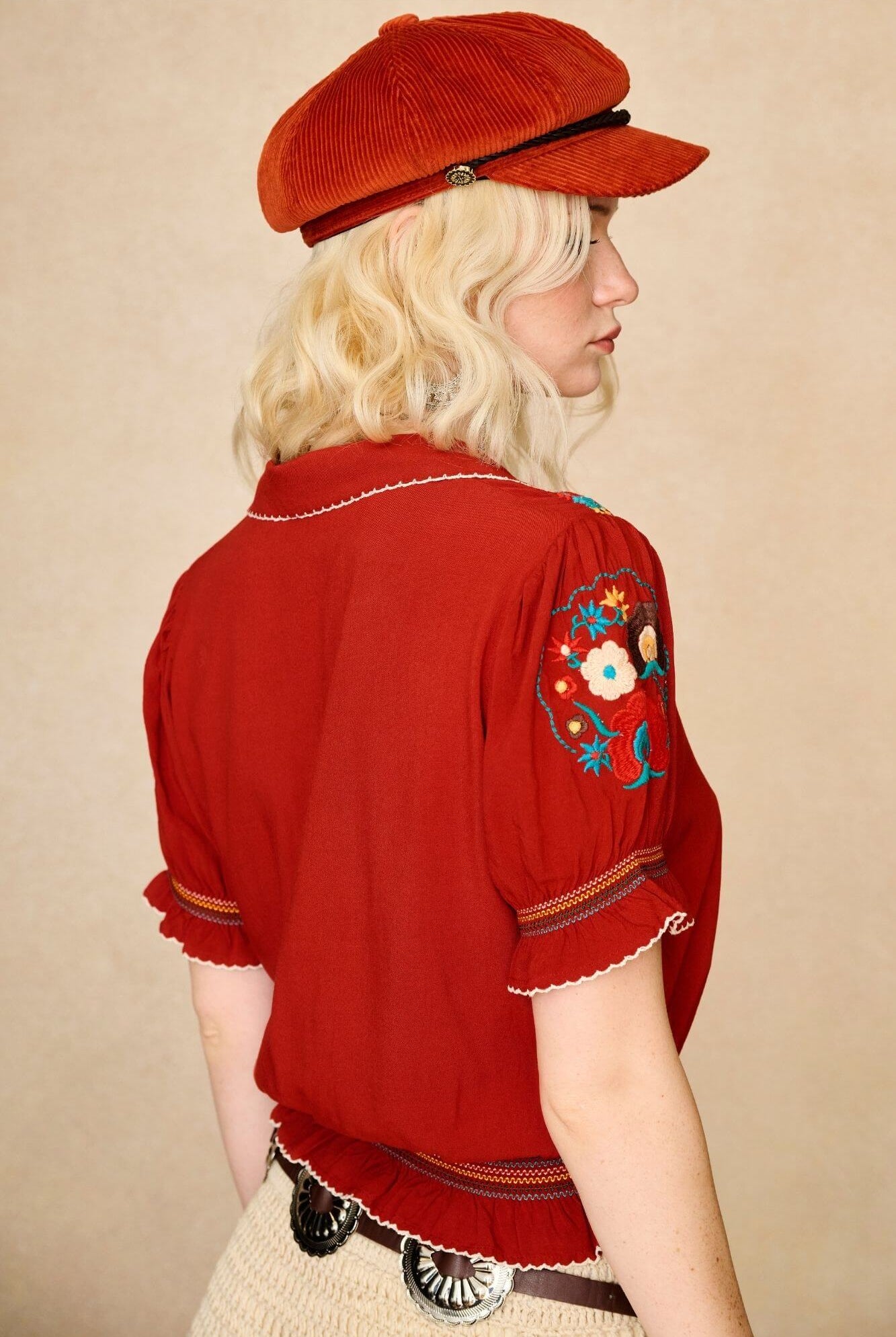 Model wears red floral embroidered Penny Lane blouse in soft cotton with shirred details. A vintage-inspired boho blouse made for everyday and festival styling by The Hippie Shake. Back view