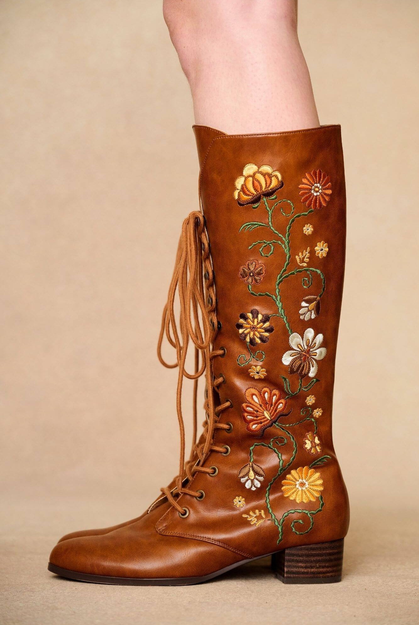 Close up of brown embroidered Penny Lane boots in tan faux leather with lace-up front and block heel. Vintage-inspired boho boots by The Hippie Shake