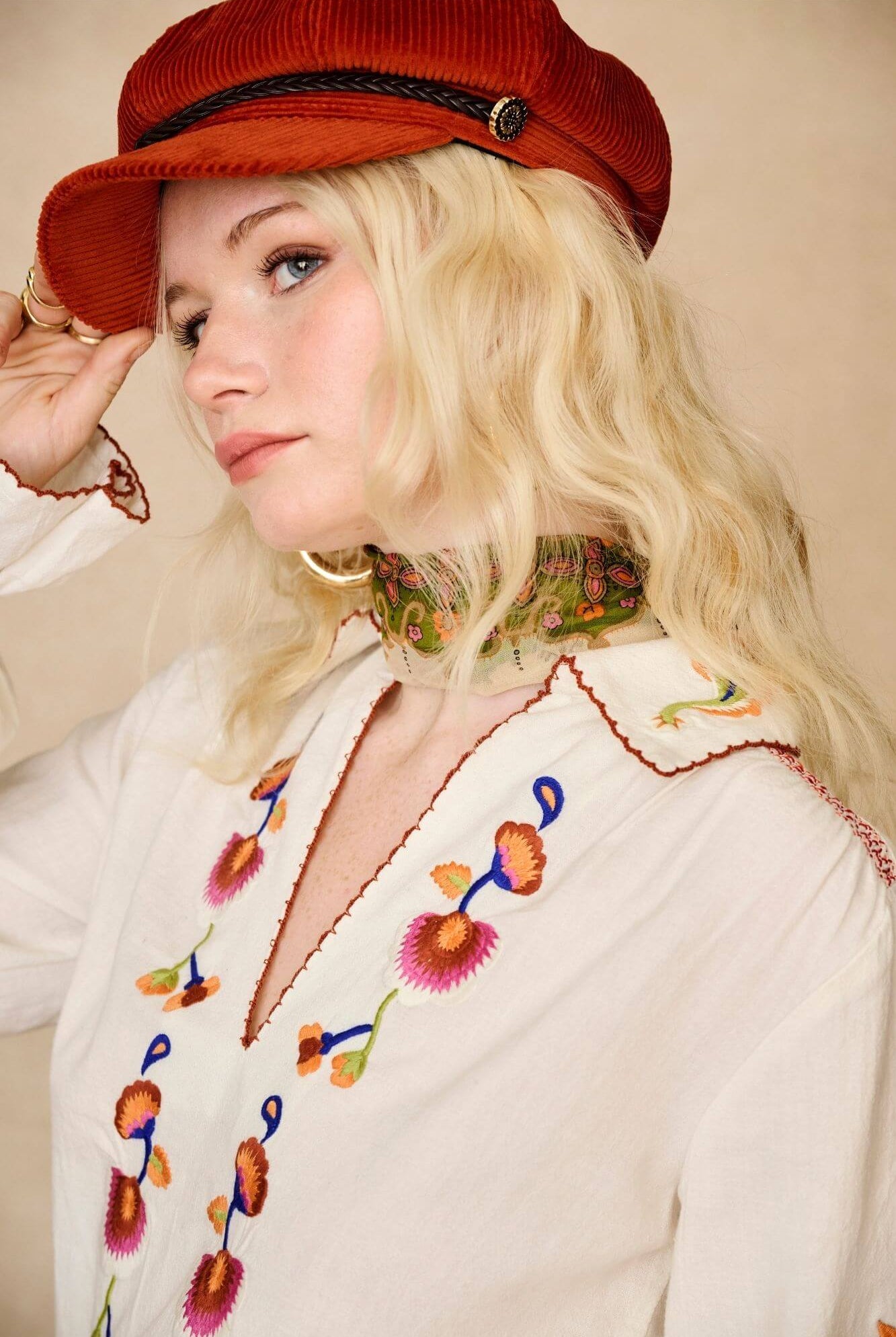Model wears cream embroidered blouse in textured cotton with floral detailing and balloon sleeves. A 70s-inspired boho blouse made for everyday vintage styling by The Hippie Shake - side view close up