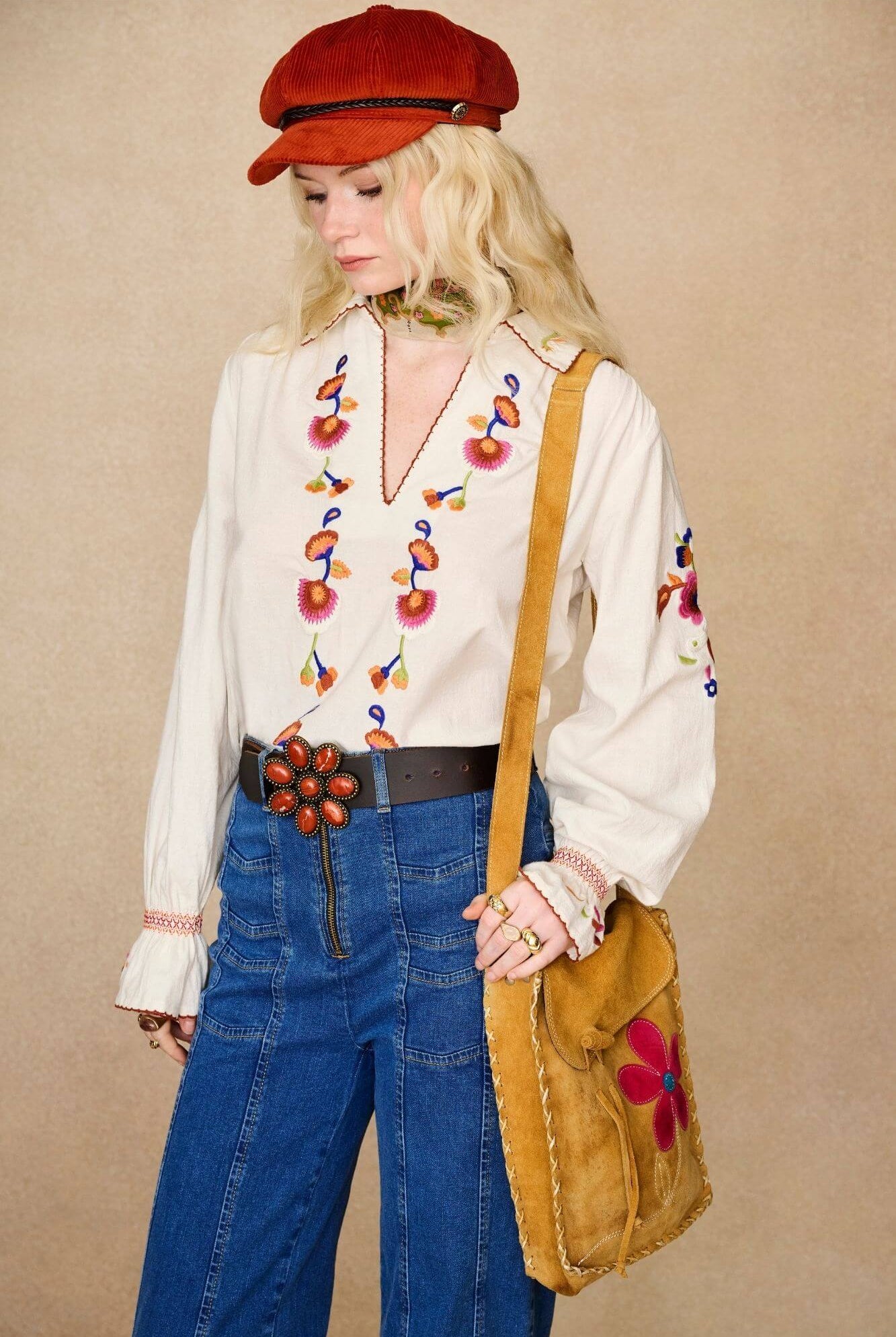 Model wears cream embroidered blouse in textured cotton with floral detailing and balloon sleeves. A 70s-inspired boho blouse made for everyday vintage styling by The Hippie Shake - front view