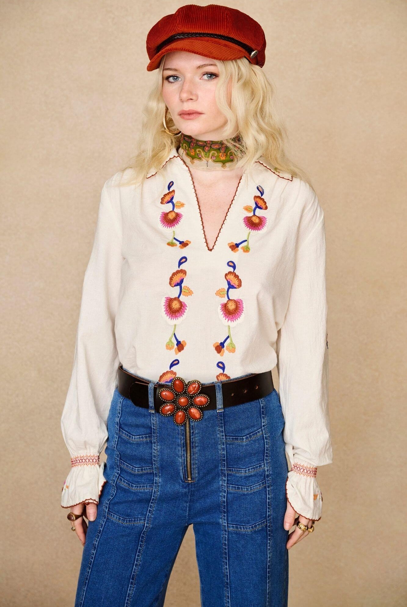 Model wears cream embroidered blouse in textured cotton with floral detailing and balloon sleeves paired with flared denim jeans. A 70s-inspired boho blouse made for everyday vintage styling by The Hippie Shake - front view