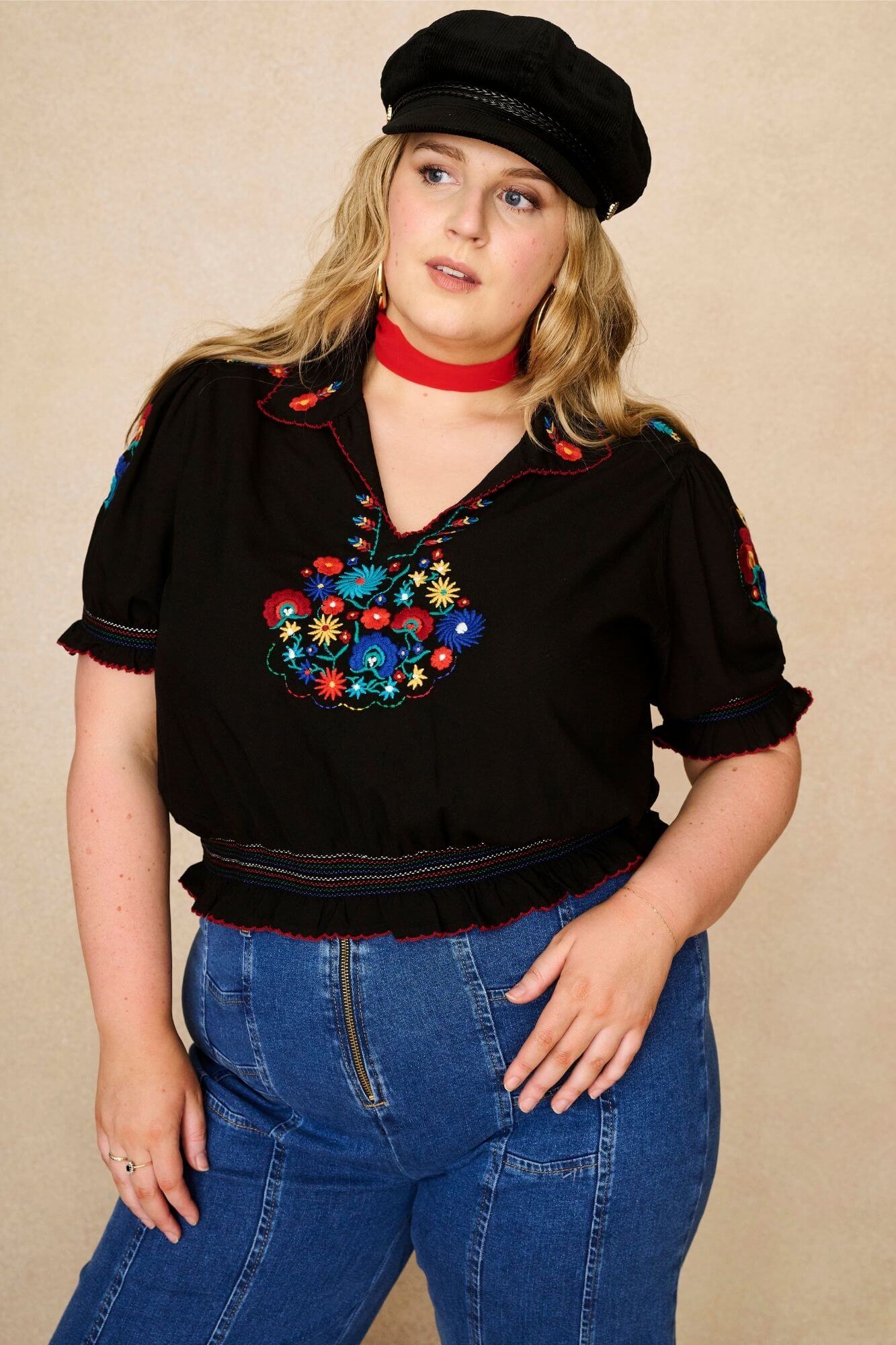 Model wears black floral embroidered blouse in soft cotton with shirred details. A vintage-inspired Penny Lane blouse made for boho, festival and everyday styling by The Hippie Shake