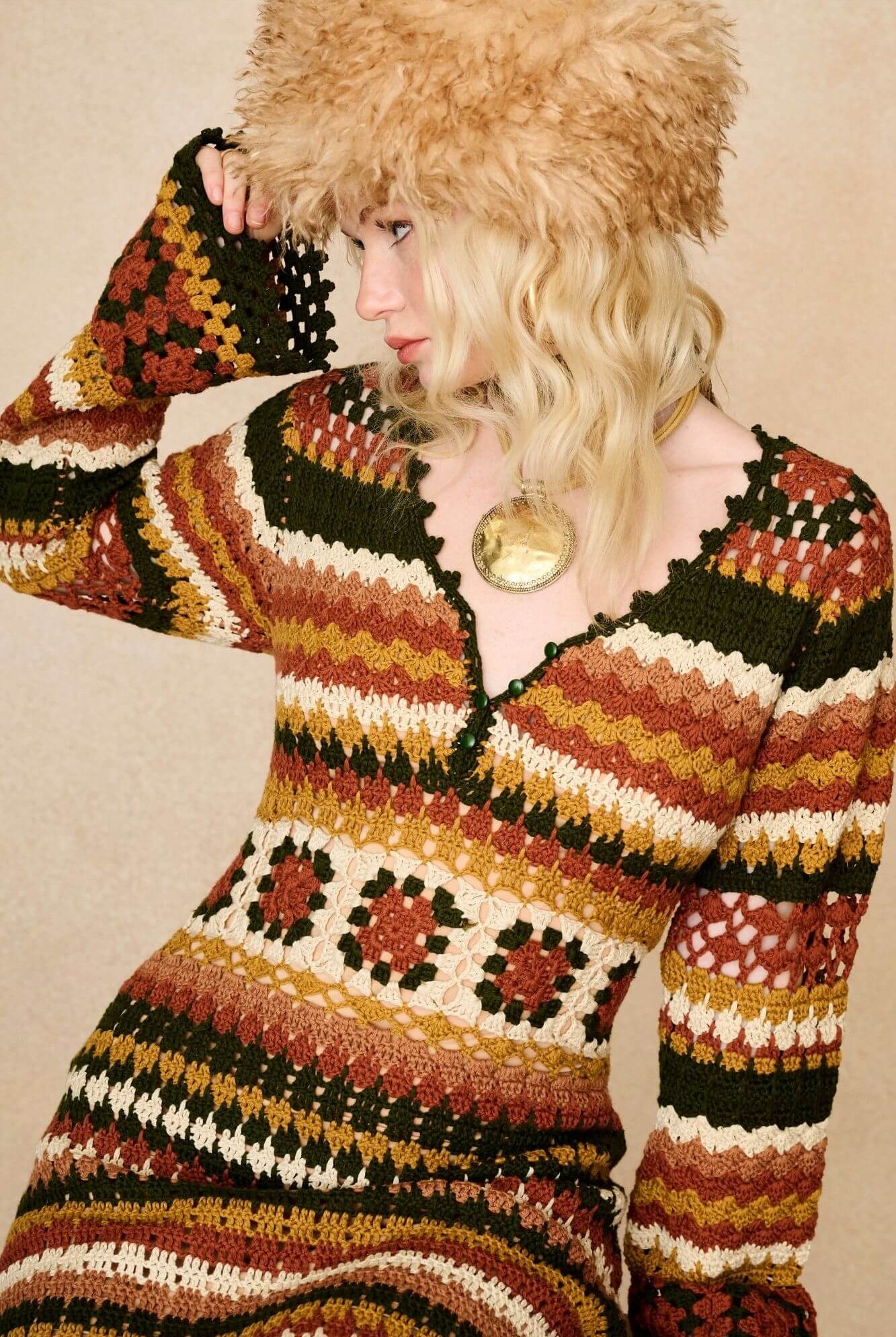 Model wears striped crochet midi dress hand crocheted in cotton with 70s-inspired detailing by The Hippie Shake. Close up with faux fur hat