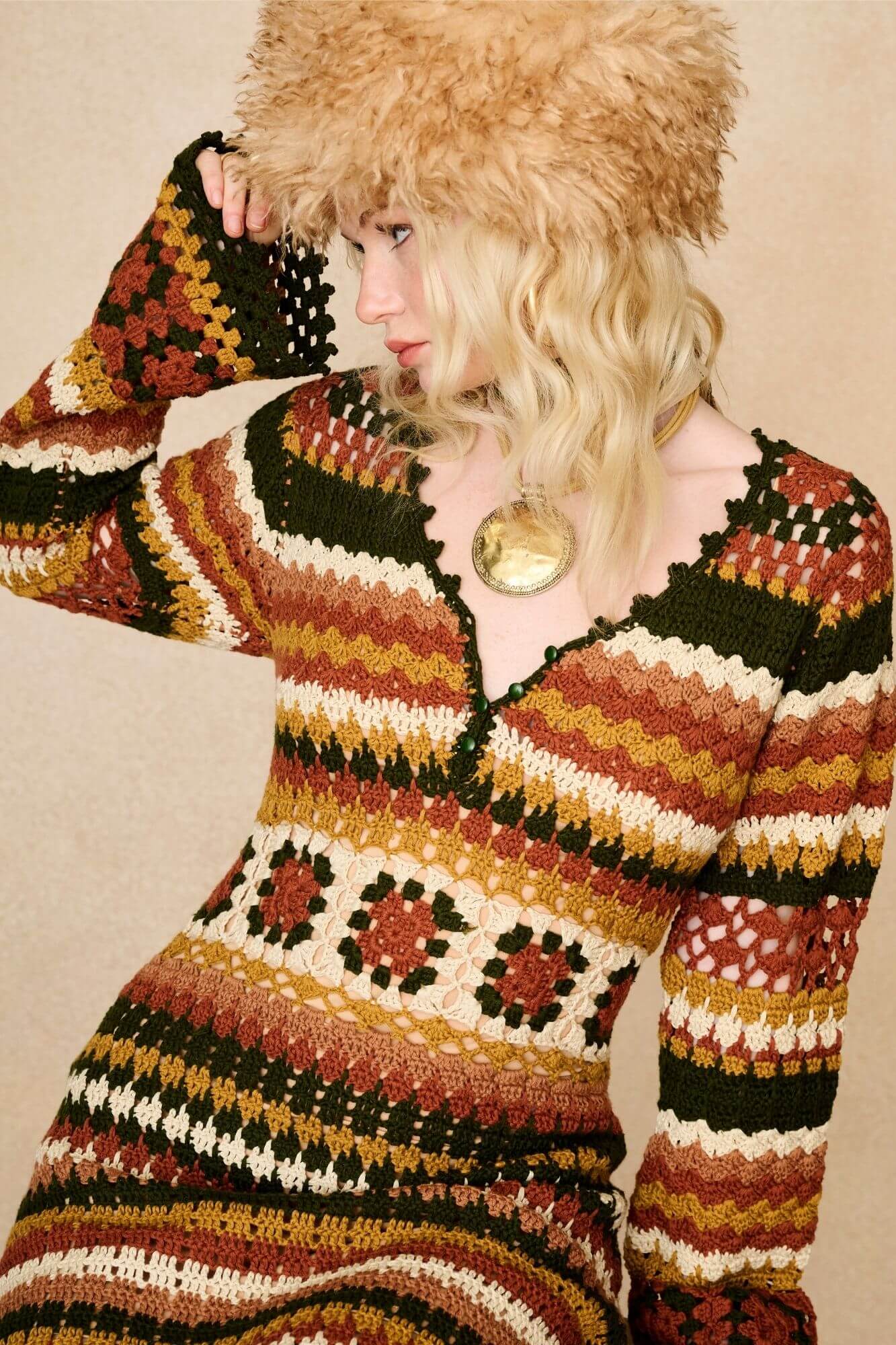 Model wears striped crochet midi dress hand crocheted in cotton with 70s-inspired detailing by The Hippie Shake. Close up with faux fur hat