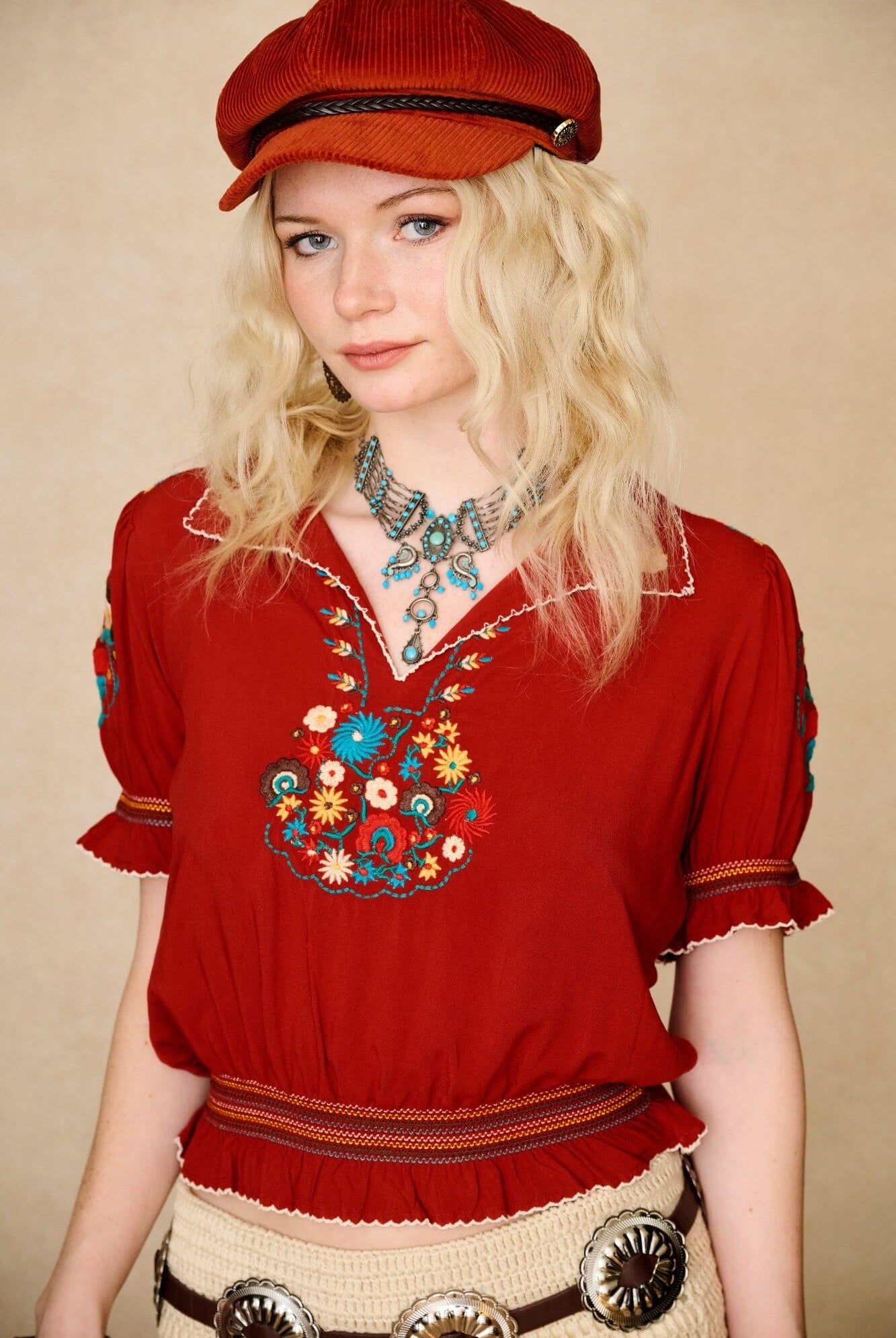 Model wears red floral embroidered Penny Lane blouse in soft cotton with shirred details. A vintage-inspired boho blouse made for everyday and festival styling by The Hippie Shake. Front view