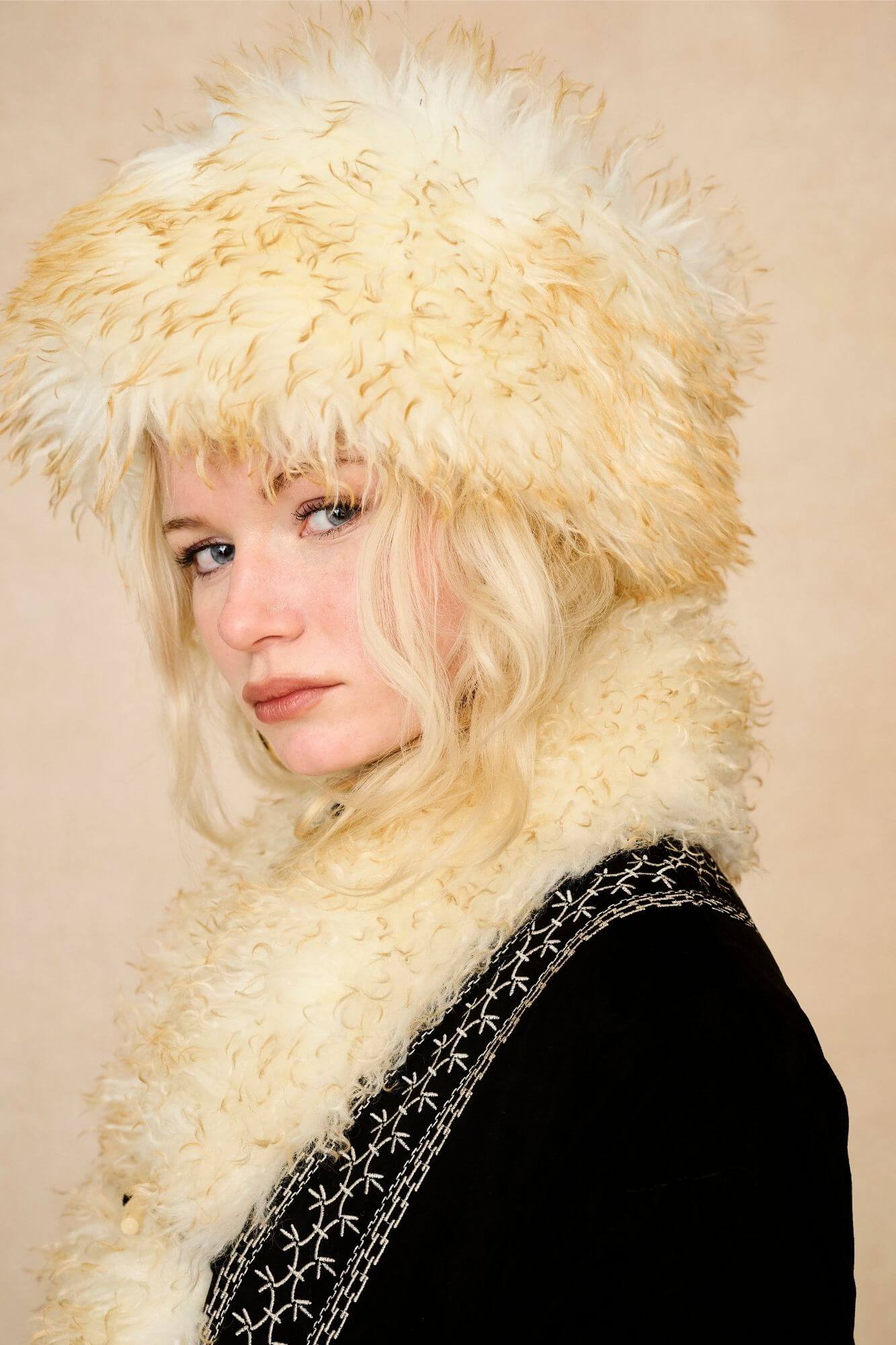 Model wears cream faux fur hat with vintage detailing and embroidered finish. A 70s-inspired boho winter hat made for statement styling by The Hippie Shake