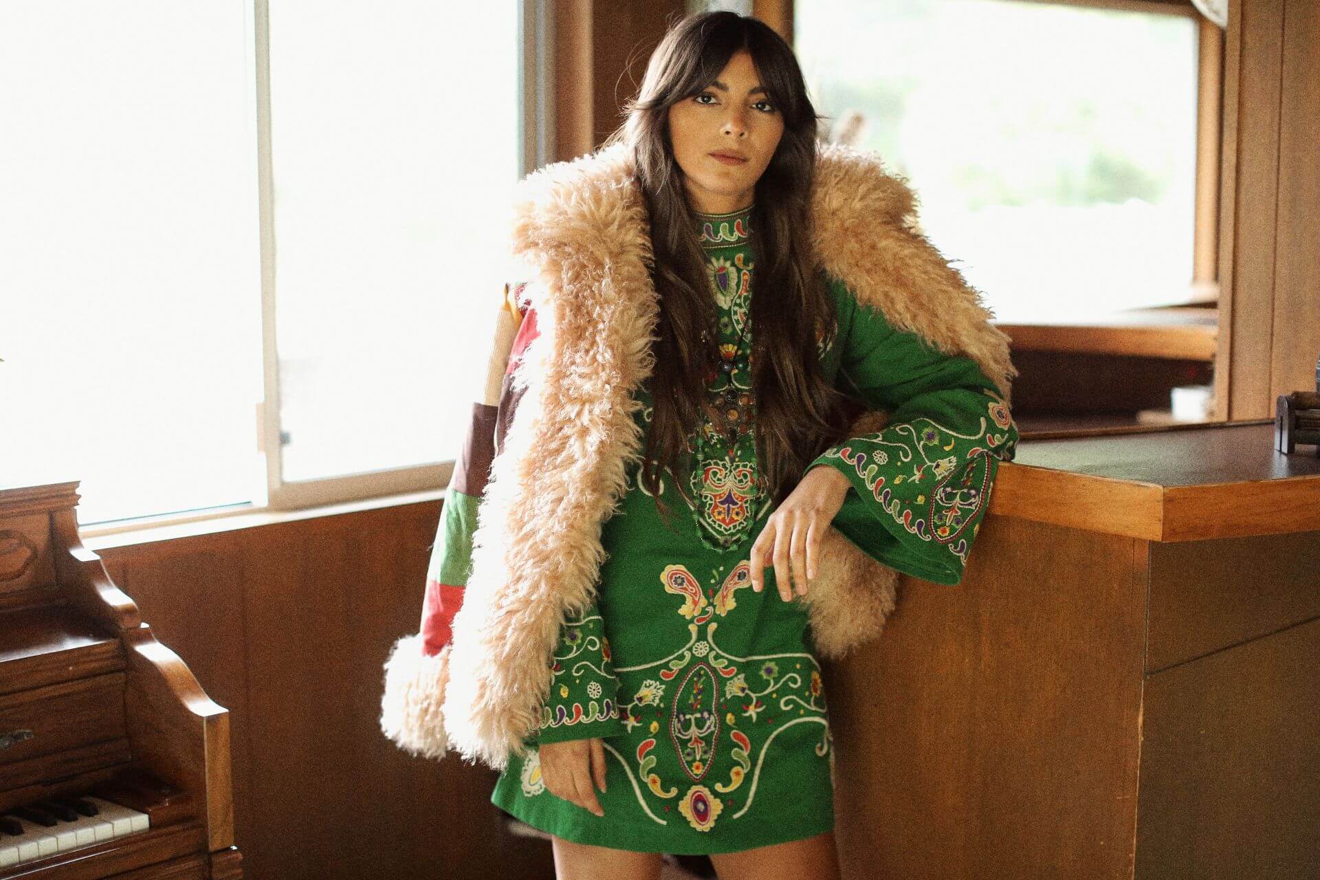 The Hippie Shake model wearing a willow green embroidered mini dress