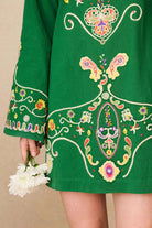 Close-up of The Hippie Shake's green folk embroidered mini dress.