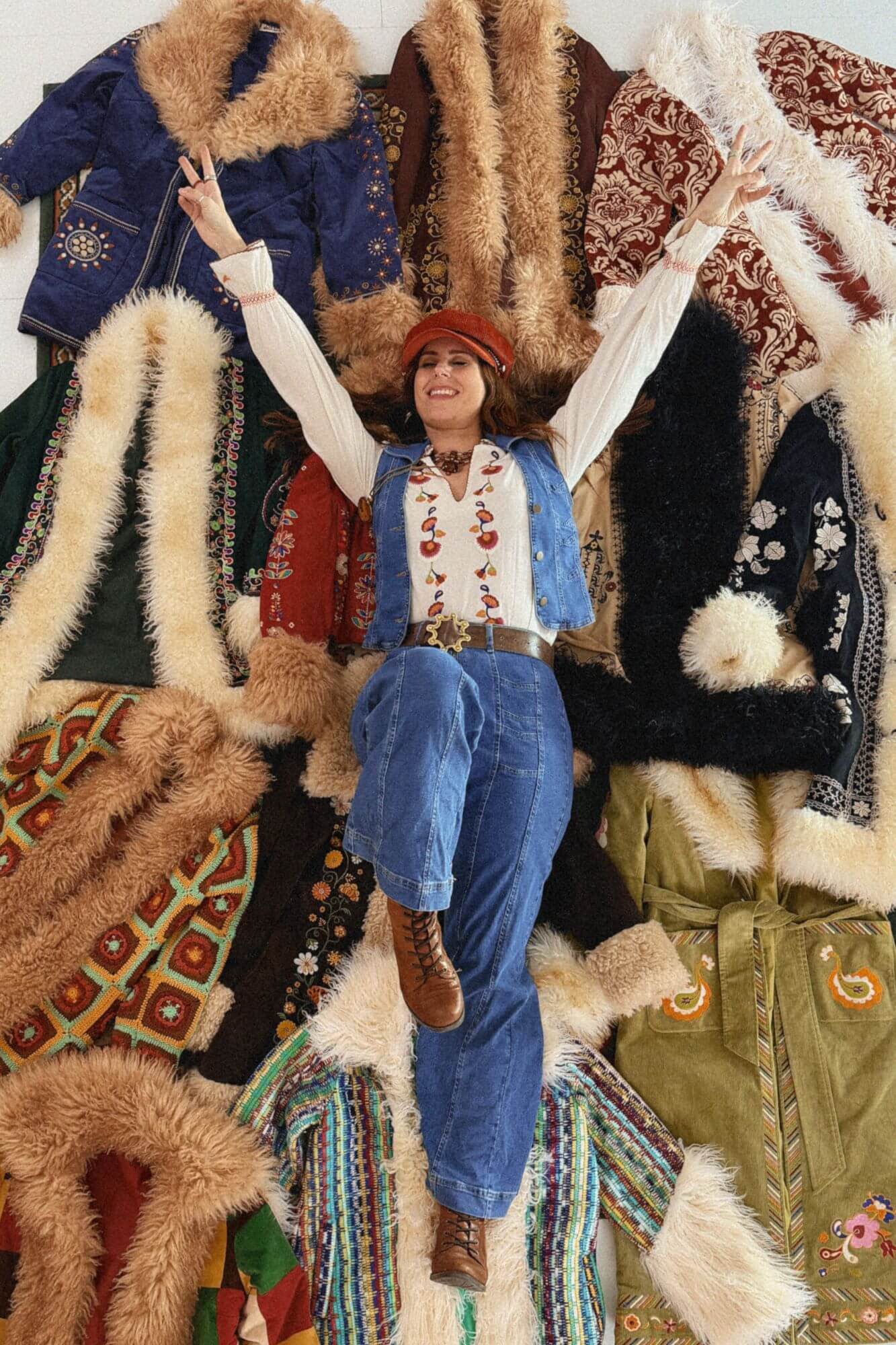 Aerial view of Naomi, Founder of The Hippie Shake laying on Penny Lane coats