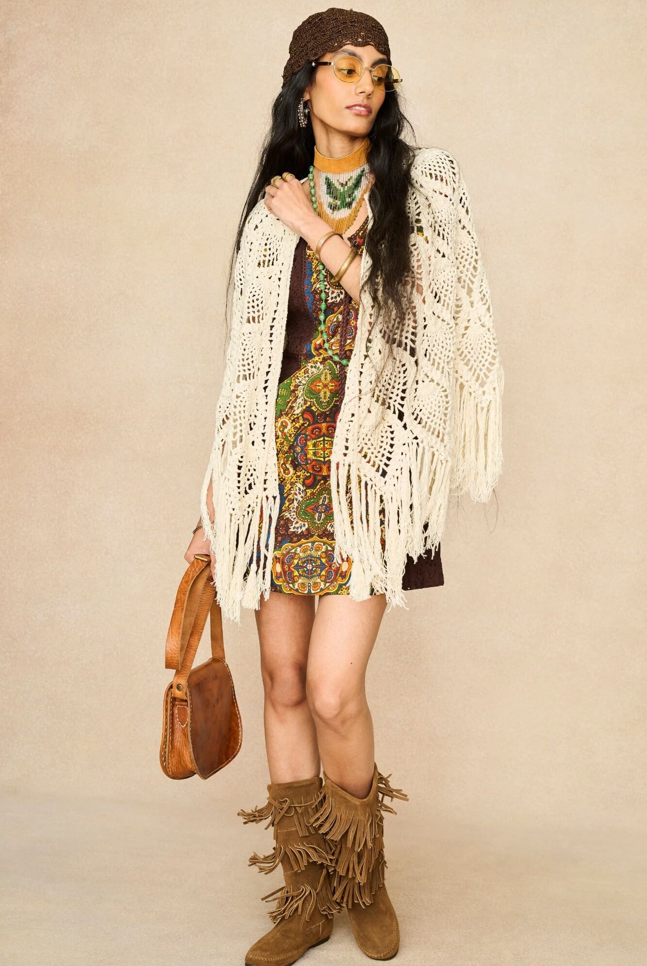 Model wearing cream crochet cape with 70s printed mini dress by The Hippie Shake, front view