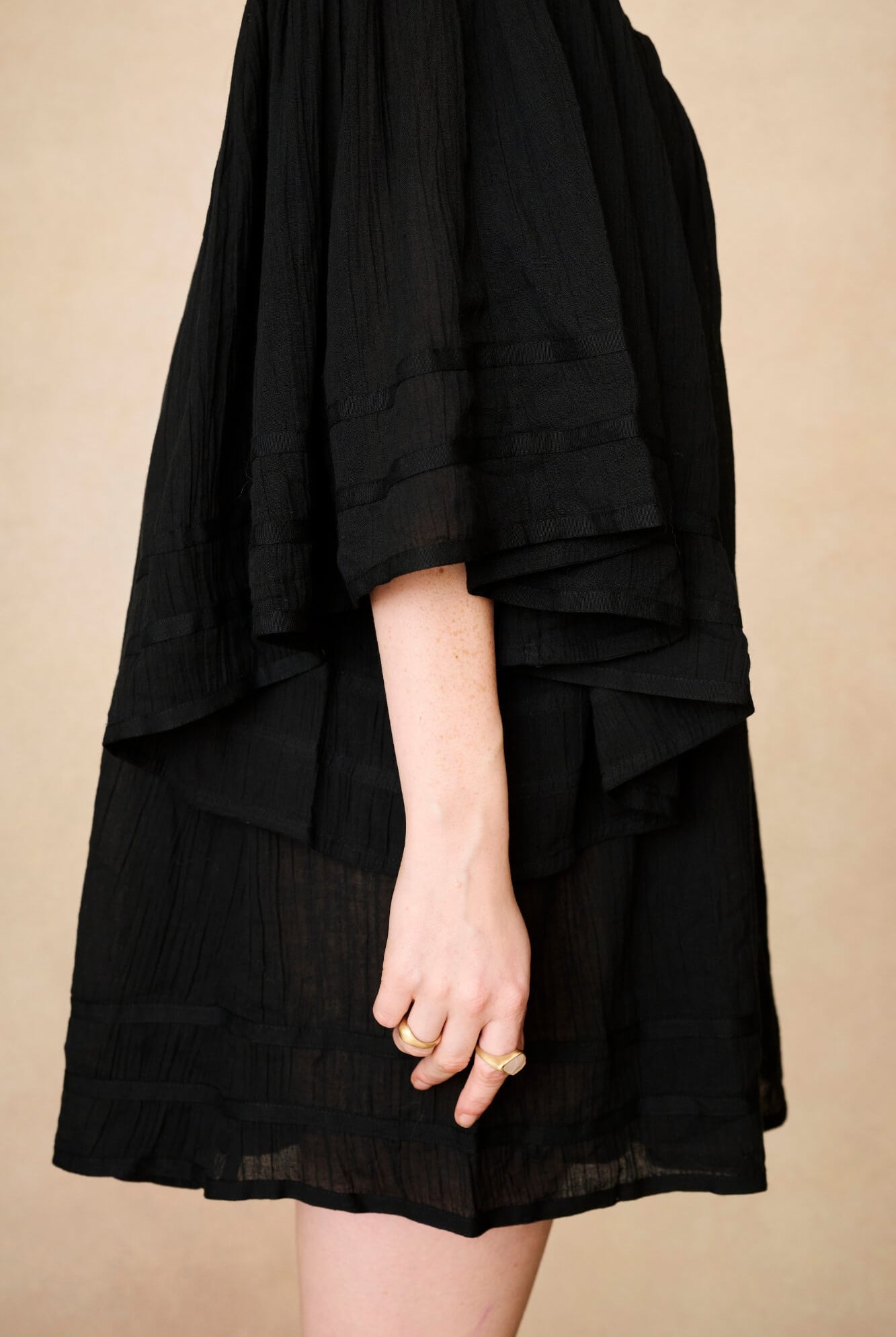 Model wearing 70s black mini dress with lace-up Penny Lane boots by The Hippie Shake, side view