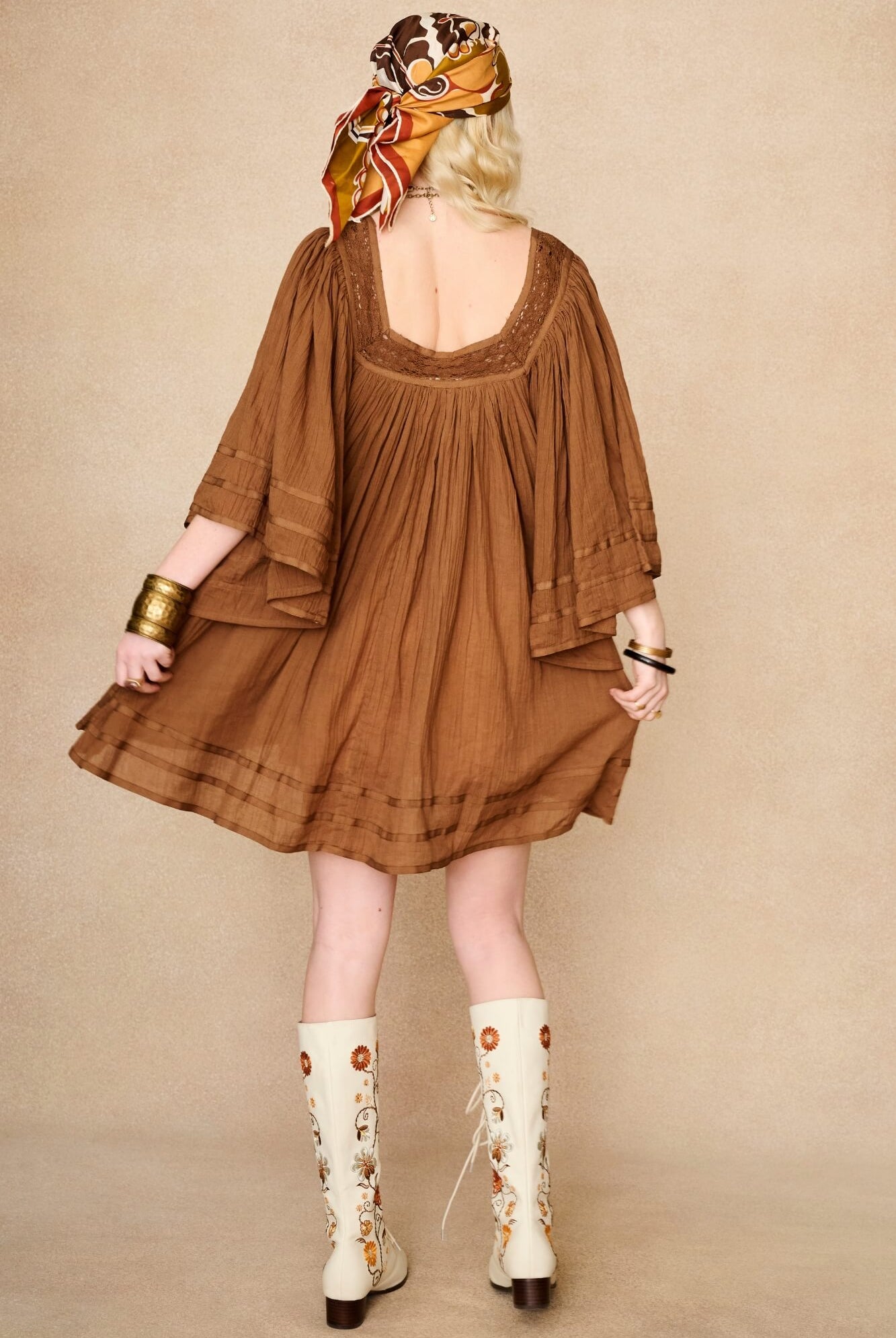 Model wearing 70s brown mini dress with lace-up Penny Lane boots by The Hippie Shake, back view