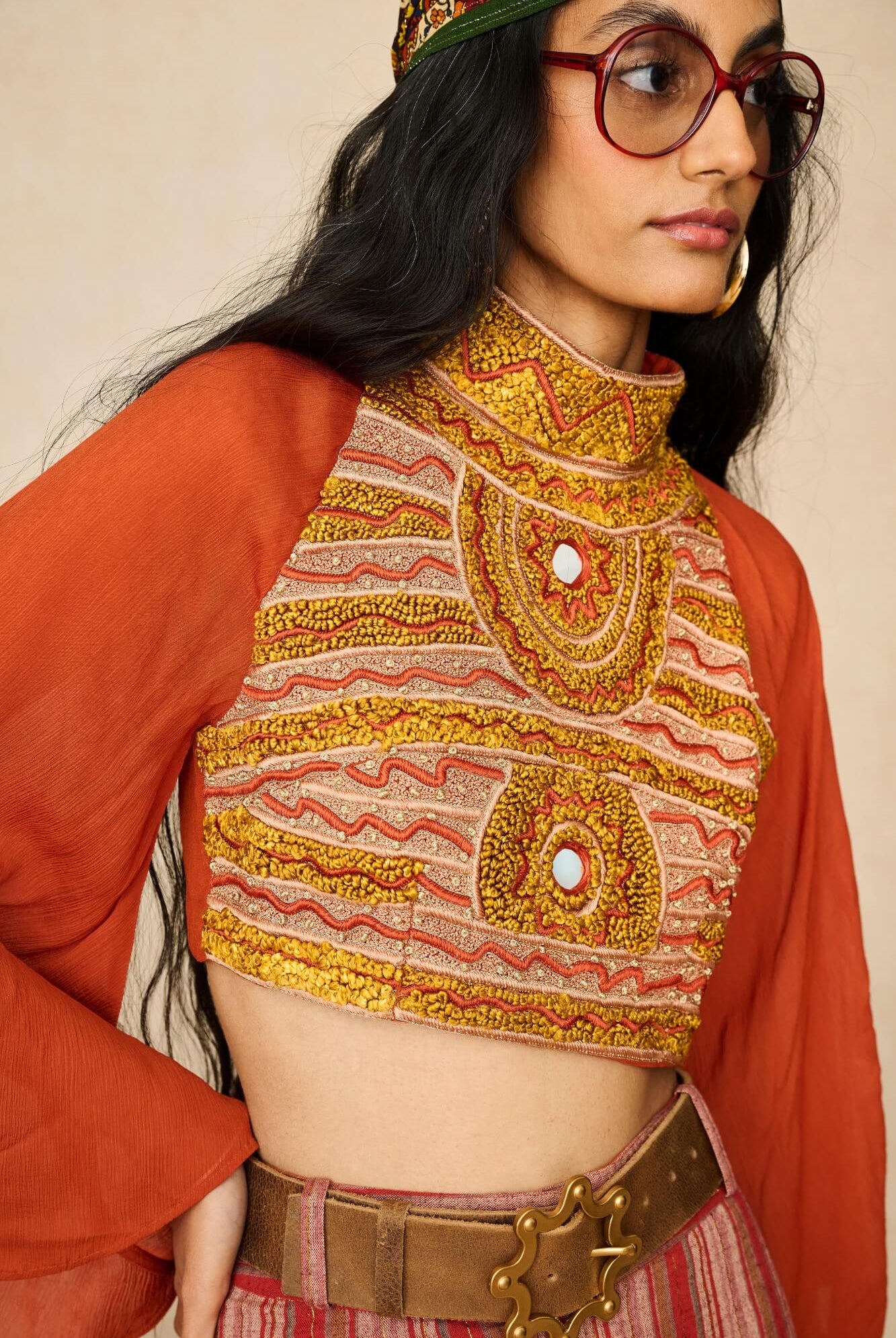 Model wearing 70s orange beaded top with striped trousers by The Hippie Shake, close up