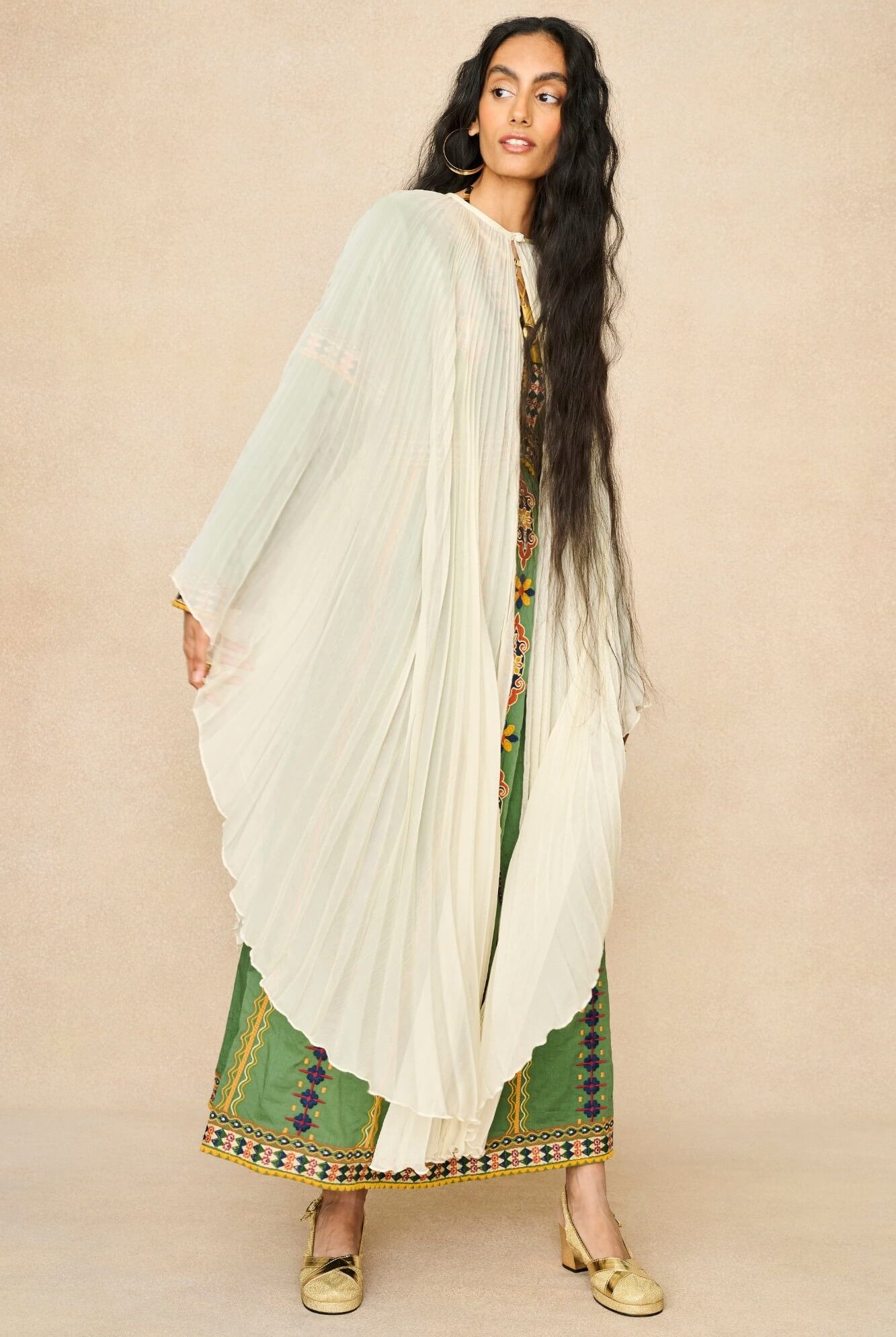 Model wearing 70s cream cape by The Hippie Shake, side view