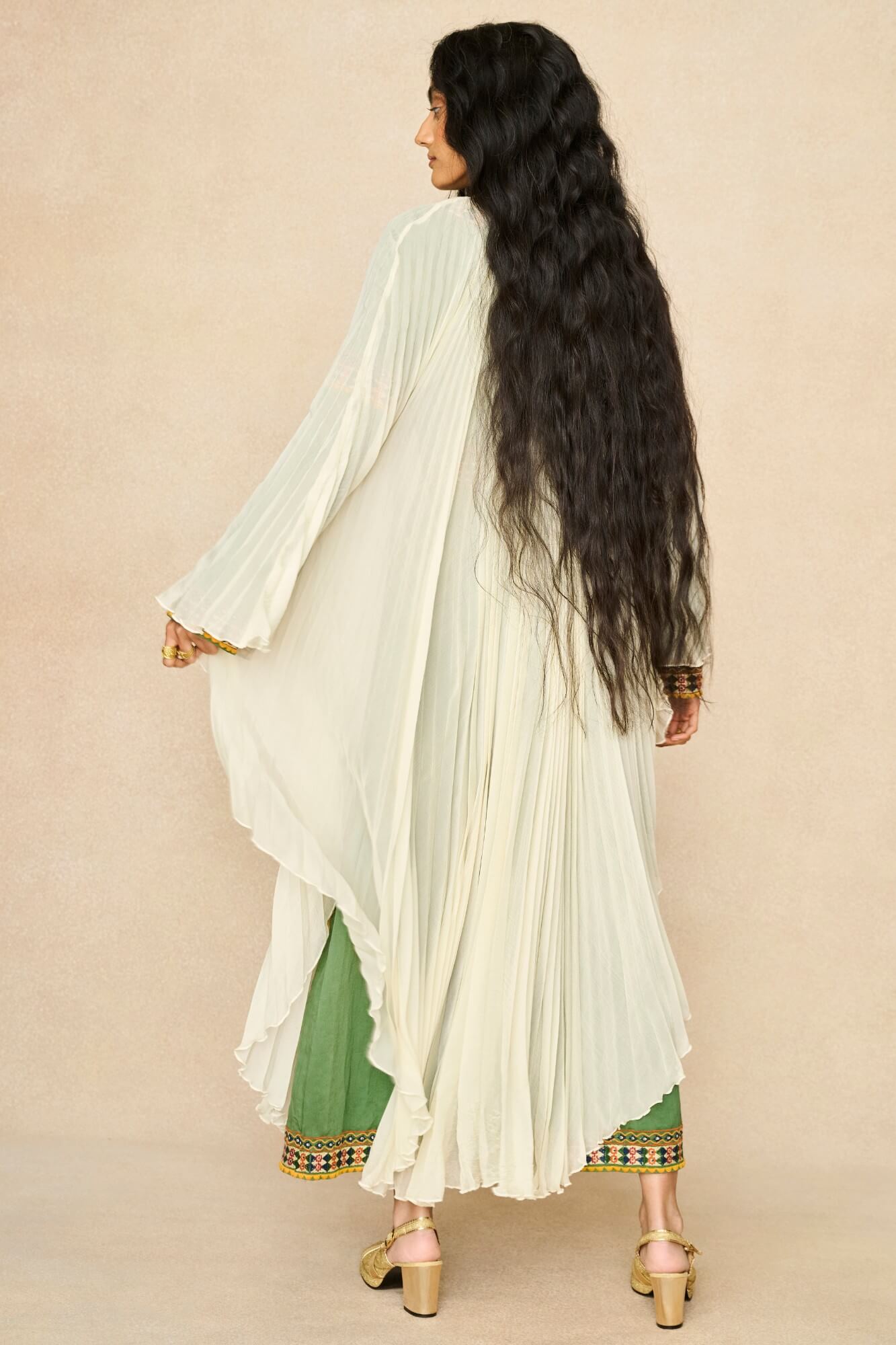 Model wearing 70s cream cape by The Hippie Shake, back view