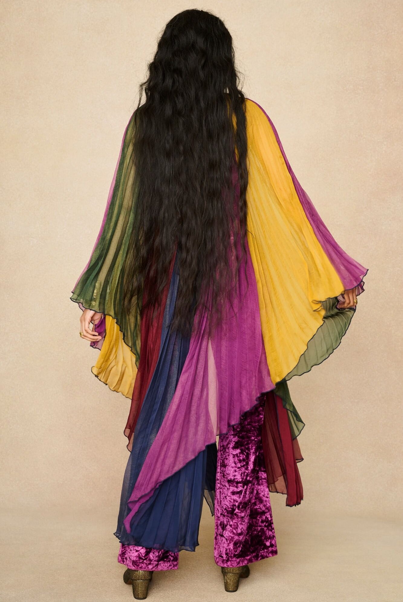 Model wearing rainbow striped cape by The Hippie Shake, back view