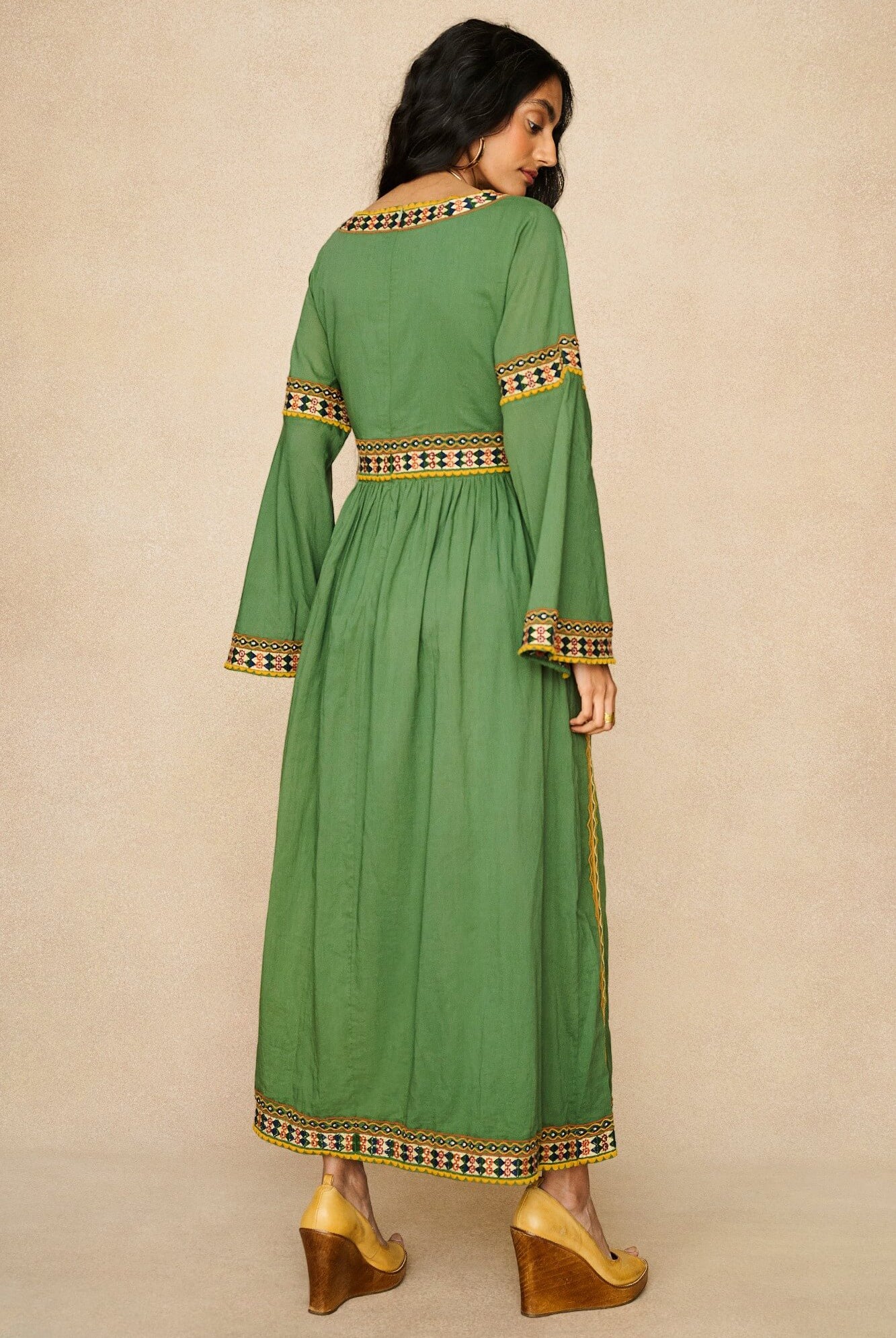 Model wearing 70s green embroidered maxi dress by The Hippie Shake, back view