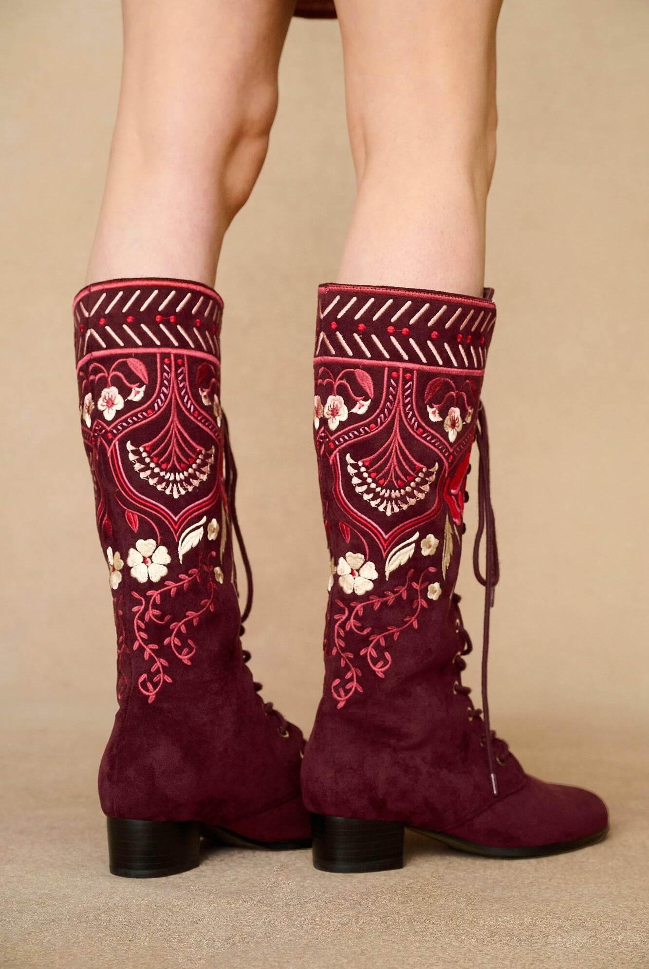 Model wearing burgundy lace-up Penny Lane boots with penny lane coat from Pamela Des Barres collection by The Hippie Shake, close up