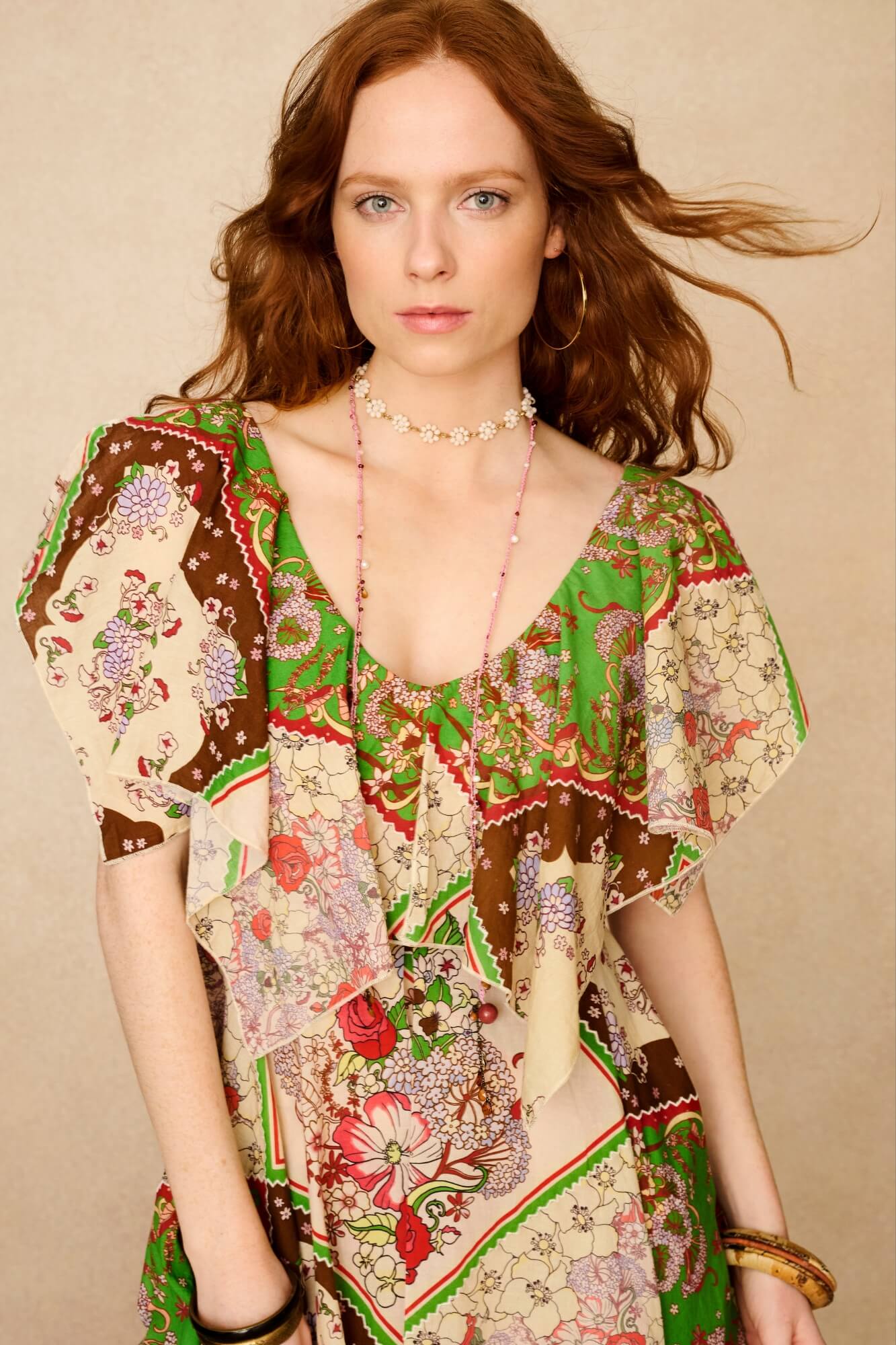 Woman wearing a colorful patterned dress against a beige background - close up