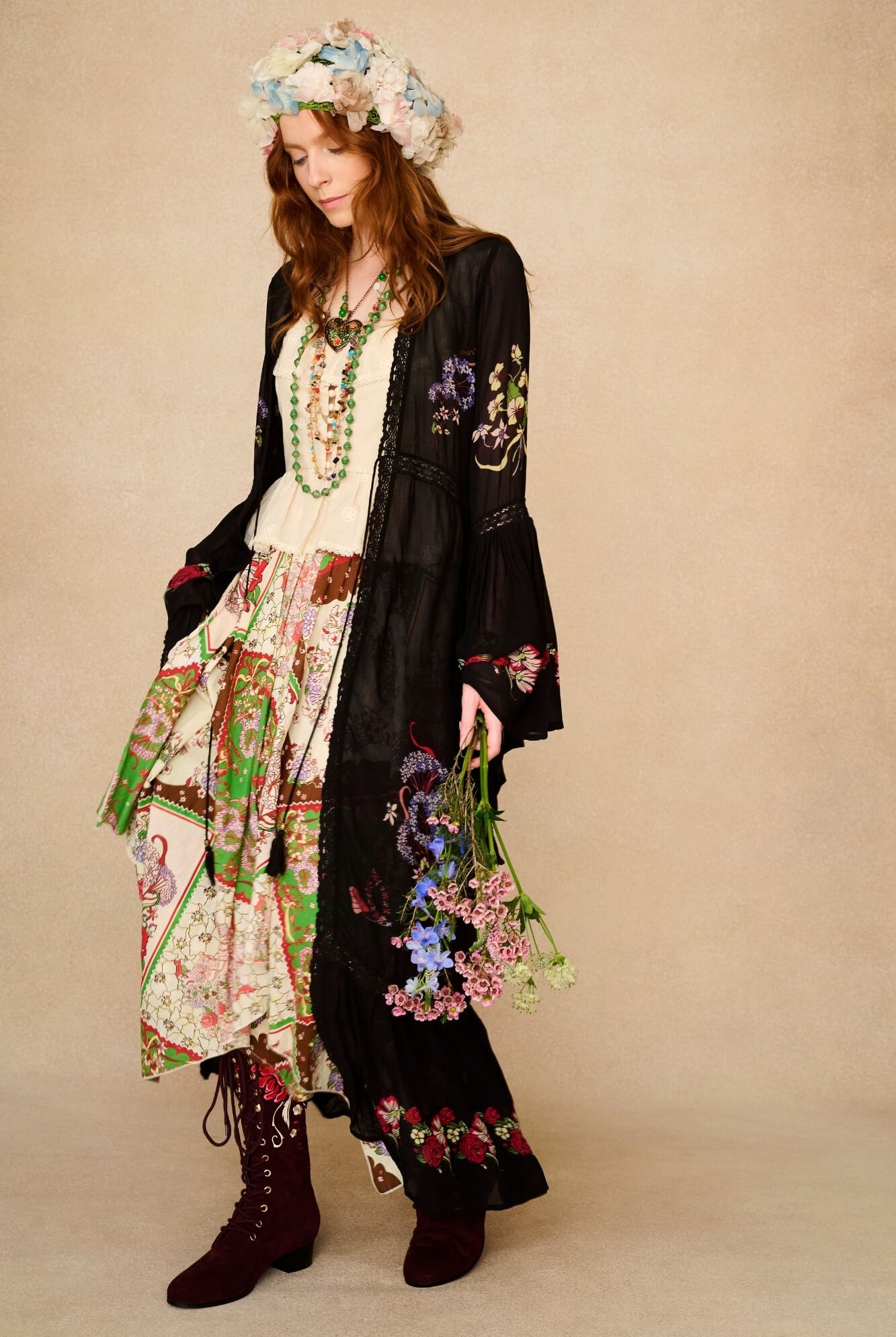 Woman in bohemian outfit with floral headpiece and accessories on a beige background
